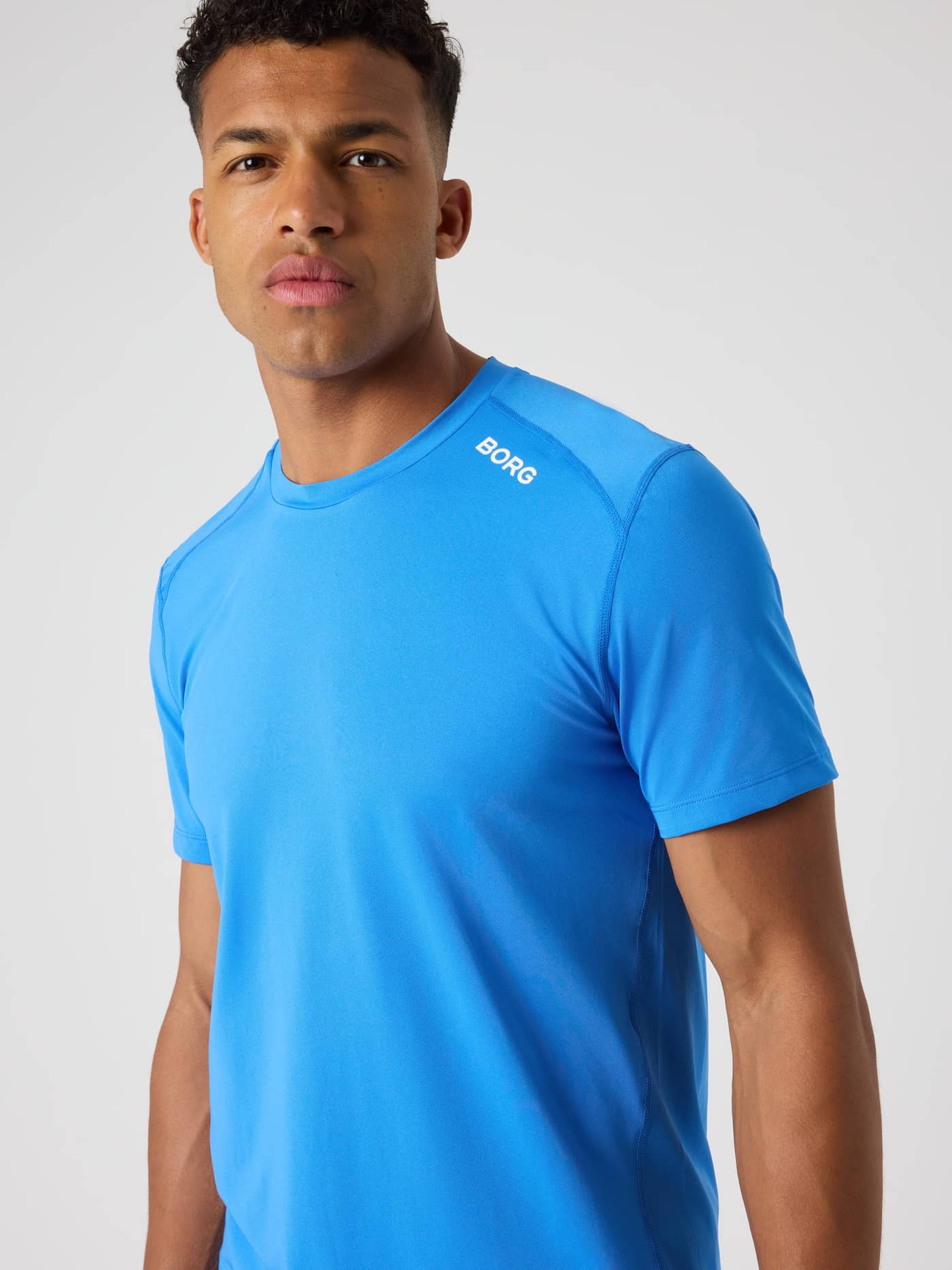 Front view of a man wearing the Palace Blue (Blue) Björn Borg Athletic T-Shirt for training, featuring a white logo. - Image 5