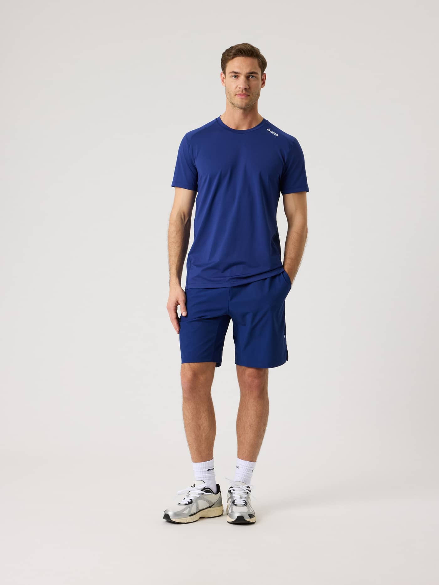 Vue de face d'un homme en Borg Athletic T-Shirt Blue Depths (Bleu) avec logo blanc, idéal pour l'entraînement. - Image 3