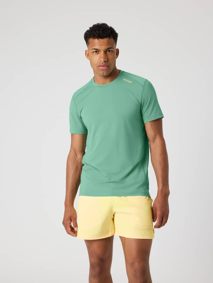Vue de face d'un homme en Borg Athletic T-Shirt Malachite Green (Vert), haut d'entraînement performant au logo jaune.