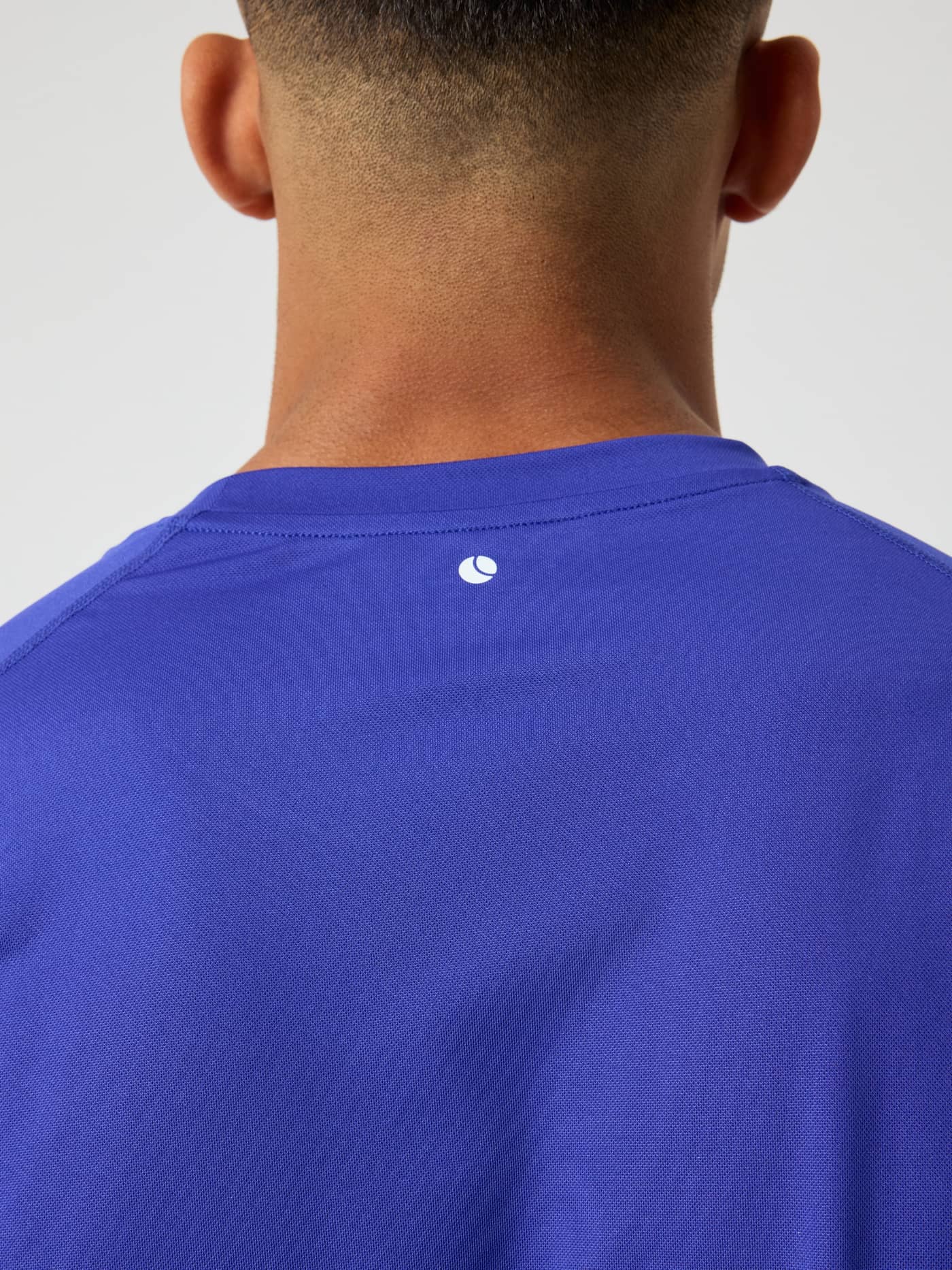 Närbild bakifrån på Borg Athletic T-Shirt i Clematis Blue (Blå) med en vit tennisbollslogotyp för tennis och träning. - Image 5