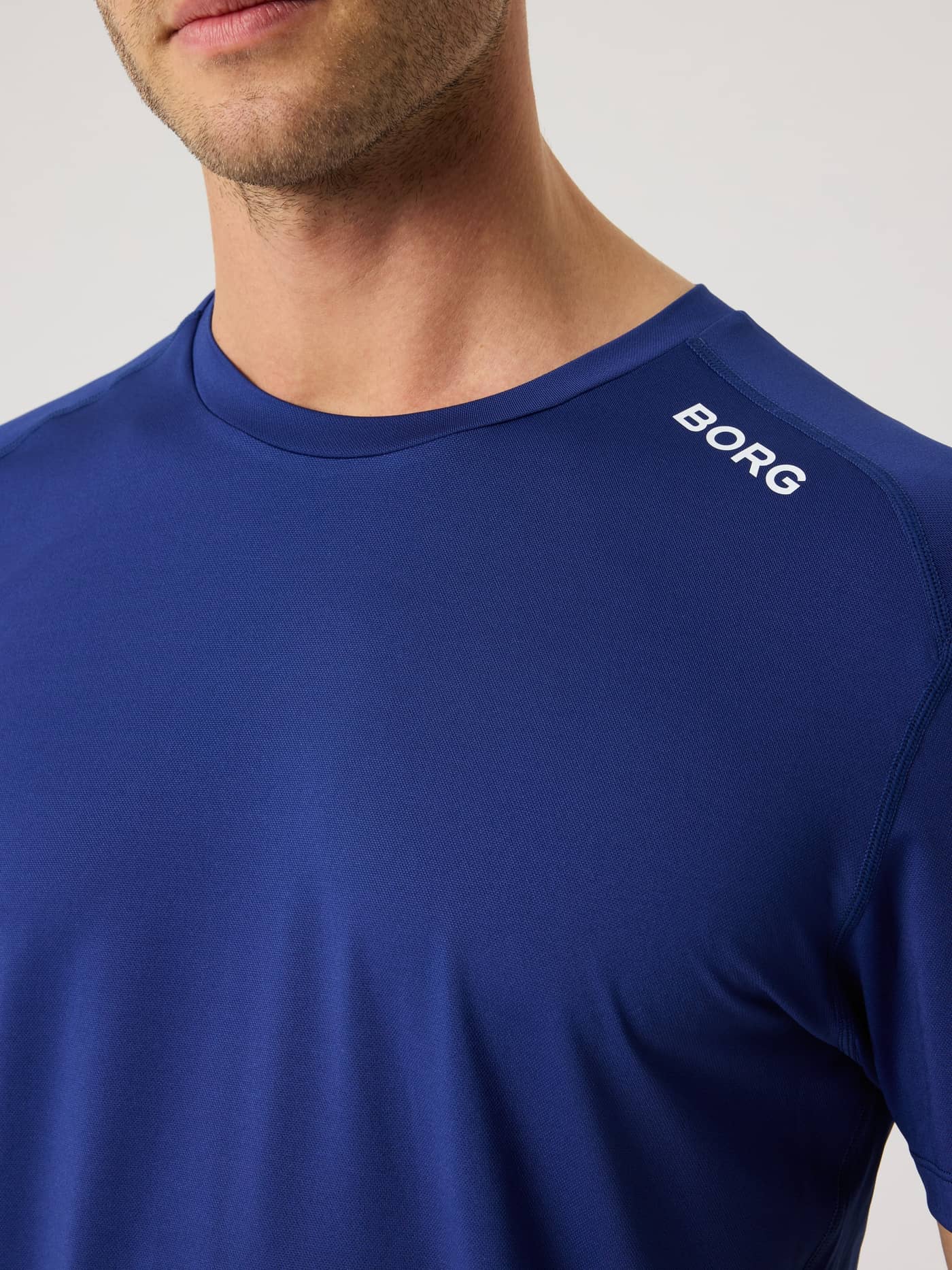 Gros plan du Borg Athletic T-Shirt pour homme en Blue Depths (Bleu) avec logo blanc sur l'épaule pour l'entraînement. - Image 5