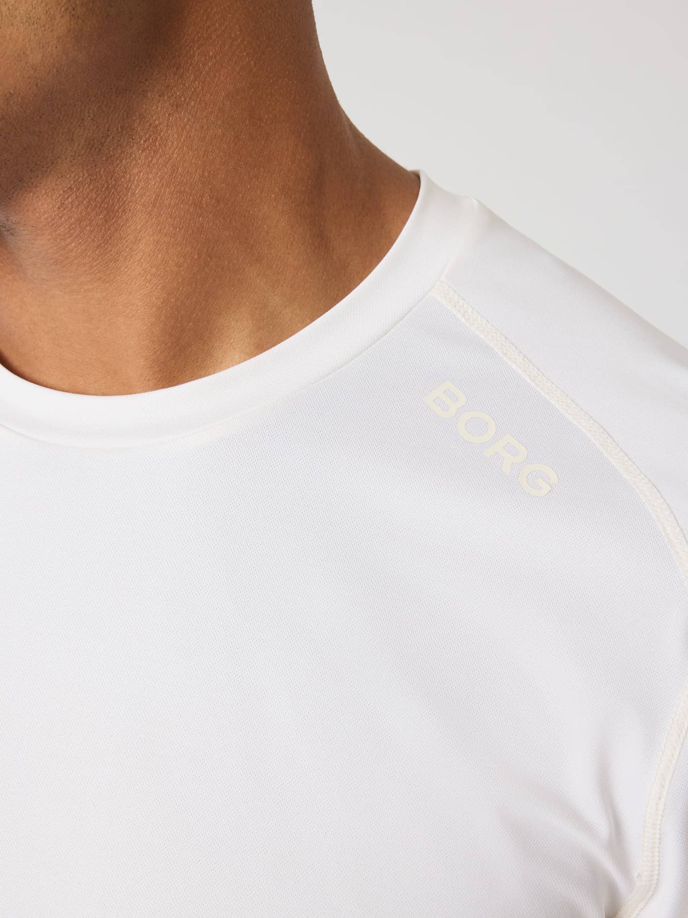 Close-up of the Borg Athletic T-Shirt in Tofu (White) with flatlock seams and a cream BORG logo for functional training. - Image 5