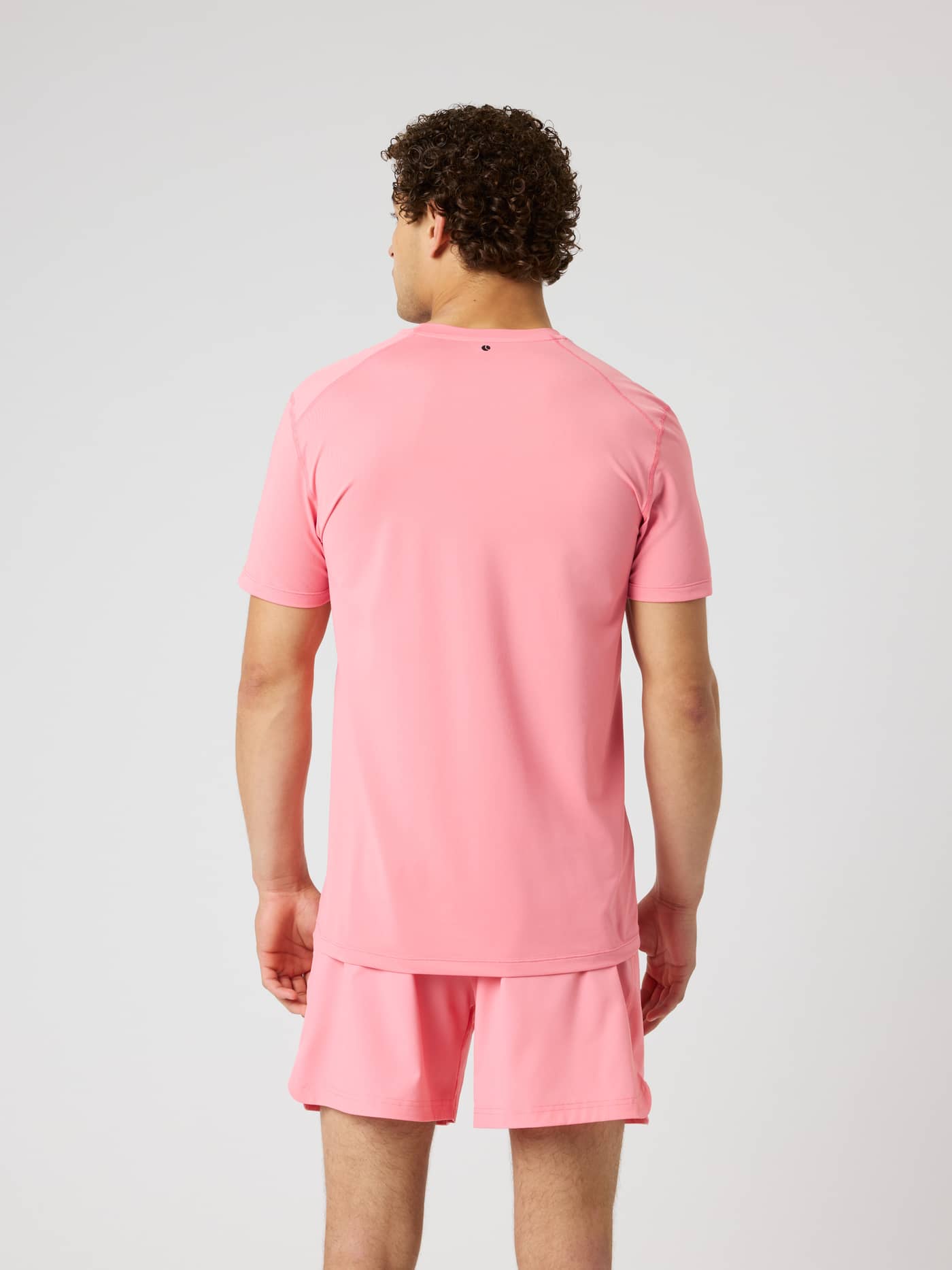 Back view of a model wearing the Borg Athletic T-Shirt in Strawberry Ice (Pink) for breathable training and tennis. - Image 2