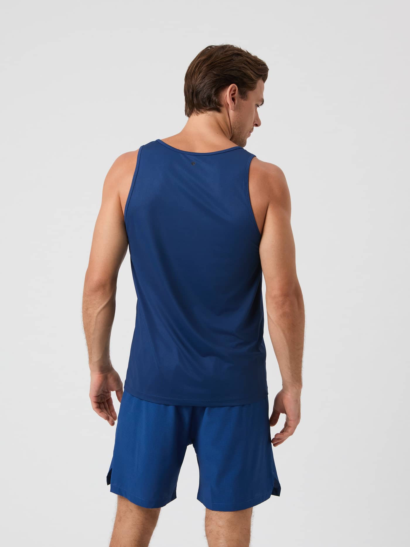 Rückansicht eines Models im Borg Athletic Tank in Estate Blue (Blau) mit Logo, ein leistungsstarkes Trainingstop. - Image 2