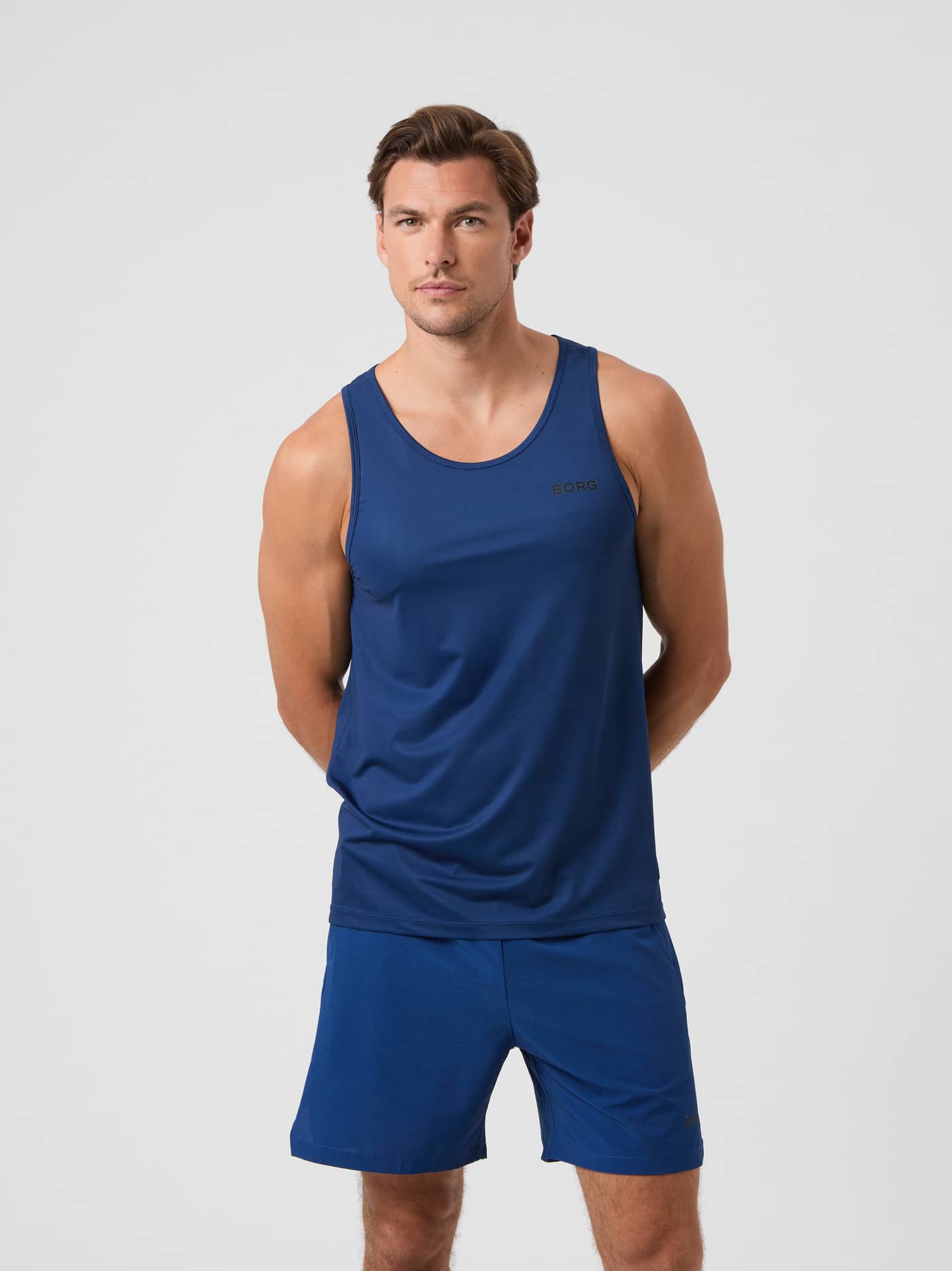 Front view of a man wearing the Björn Borg Athletic Tank in Estate Blue (Blue) with a black logo for training. - Image 1