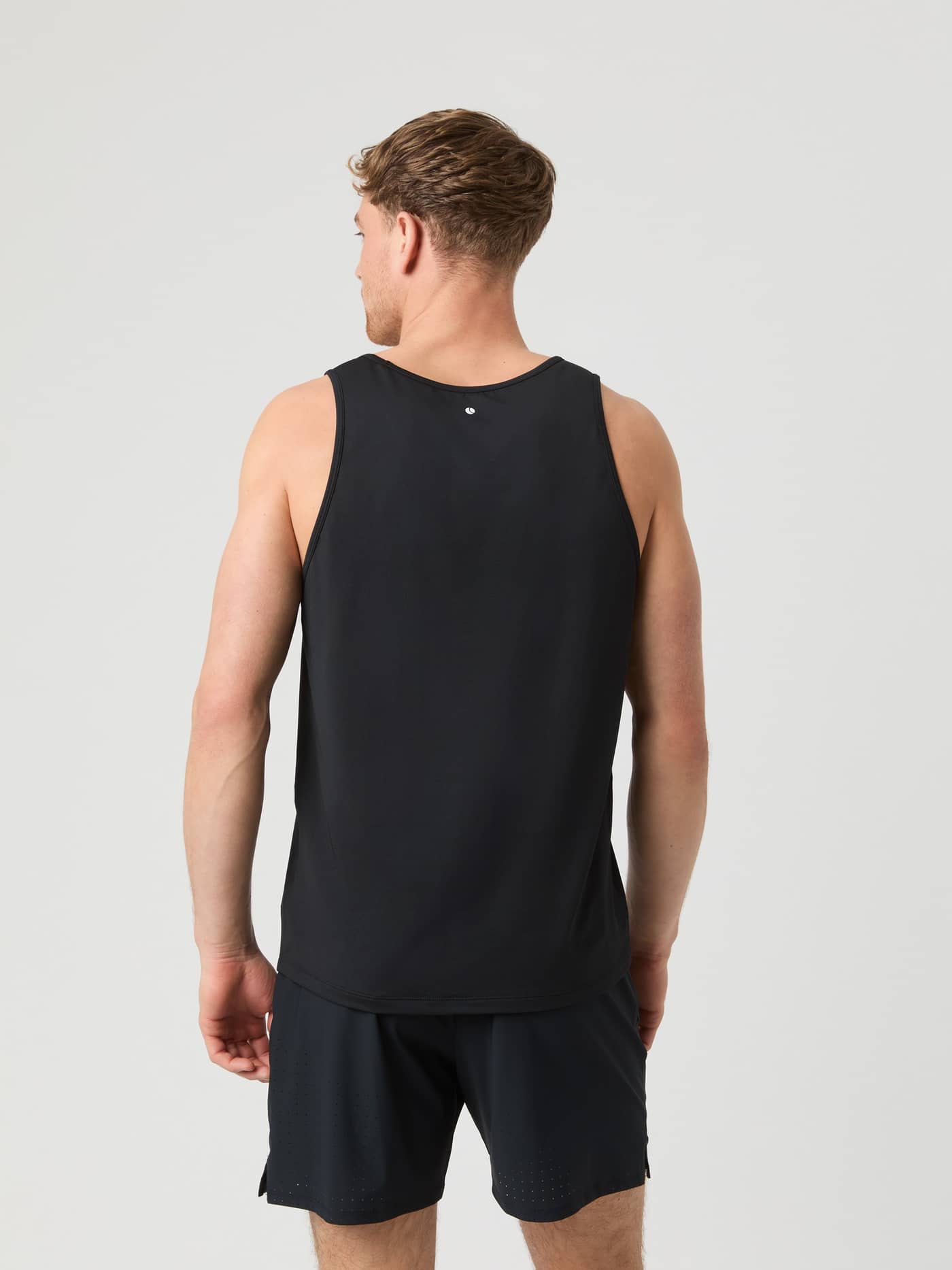 Back view of a man wearing the Björn Borg Athletic Tank in Black Beauty (Black), a training top with a white tennis logo. - Image 2