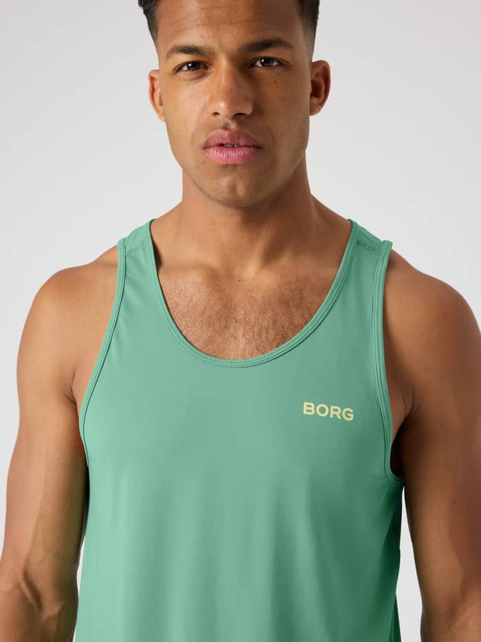 Close-up van de Borg Athletic Tank in Malachite Green (Groen), een ademende herentrainingstop met geel logo op de borst. - Image 4