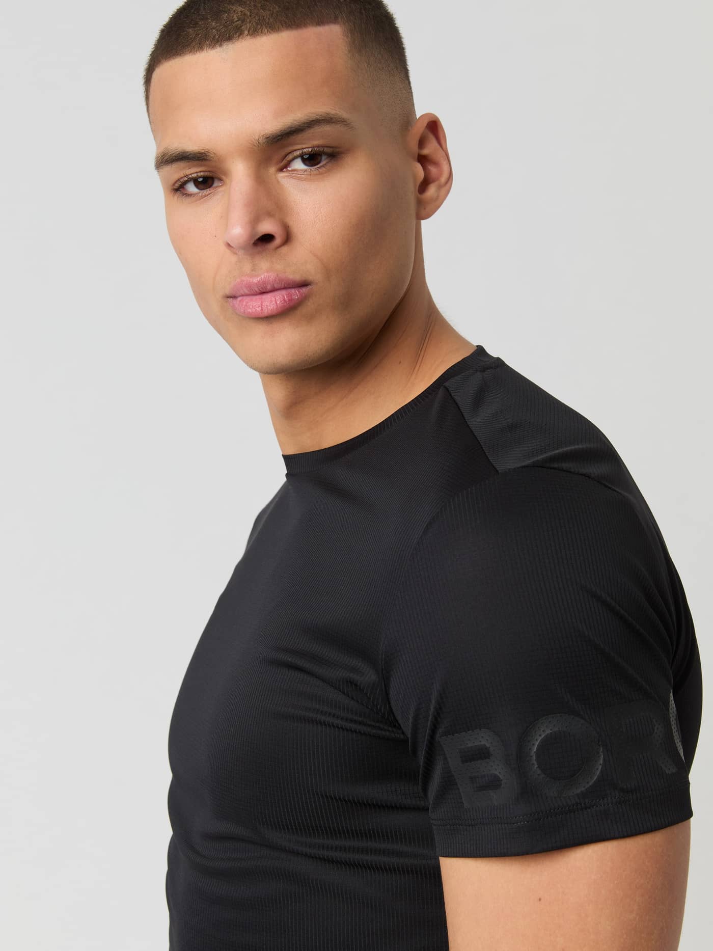 Gestructureerd Björn Borg Light T-Shirt in Black Beauty (Zwart) voor tennis met zwart mouwlogo, close-up van een model. - Image 4
