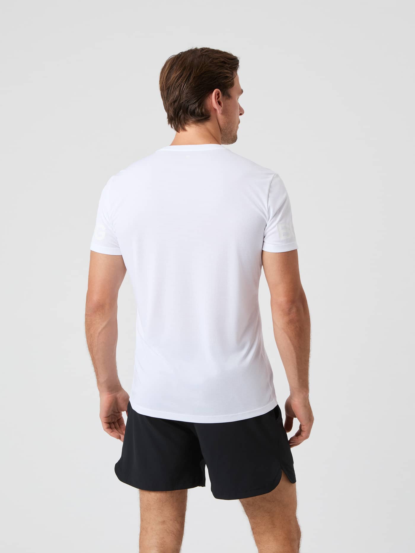 Back view of a man wearing the lightweight Borg Light T-Shirt in Brilliant White (White) for training and tennis. - Image 2
