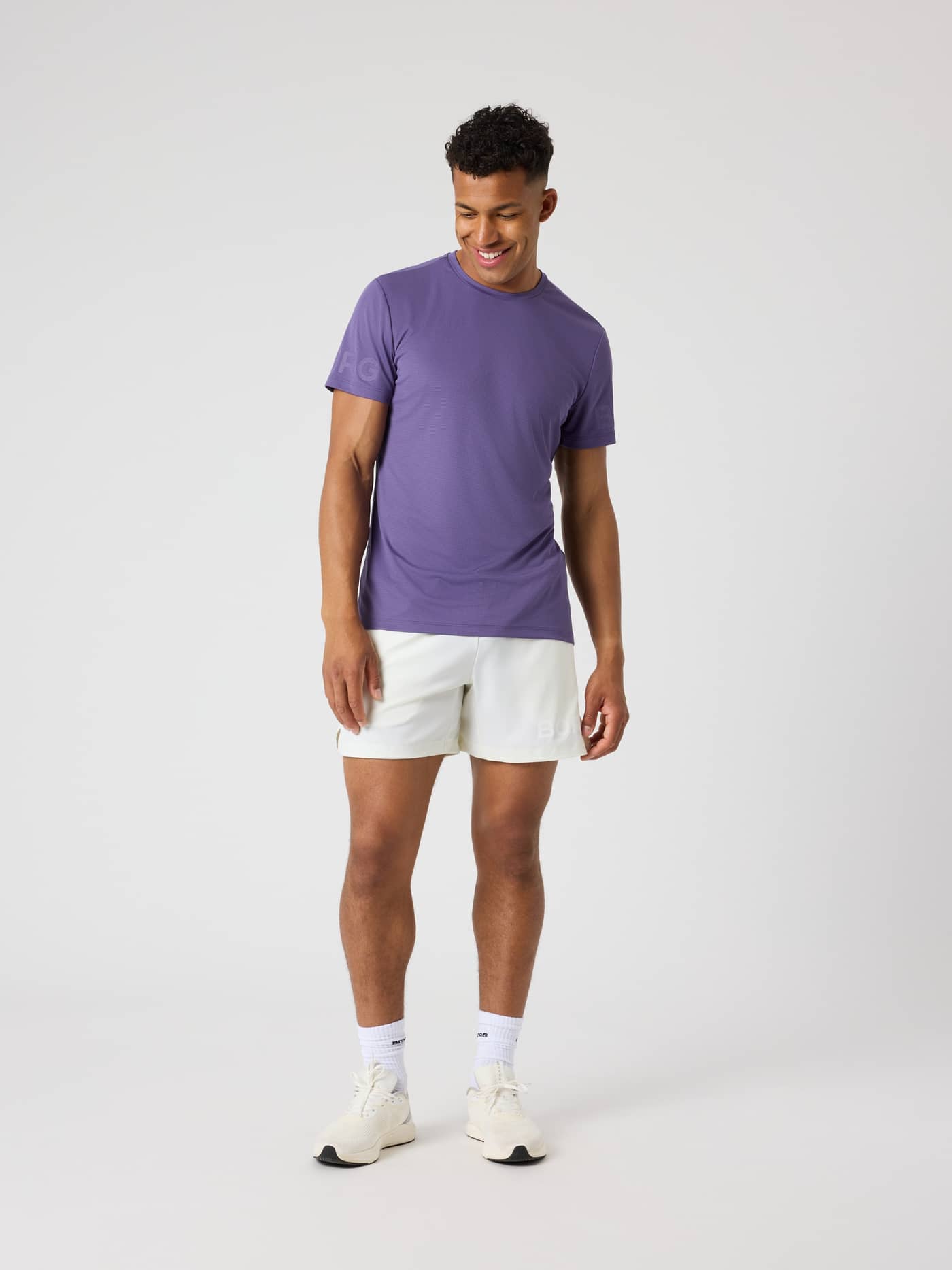 Full-body view of a man wearing the Borg Light T-Shirt in Mystical (Purple) with tonal logos for training and tennis. - Image 3