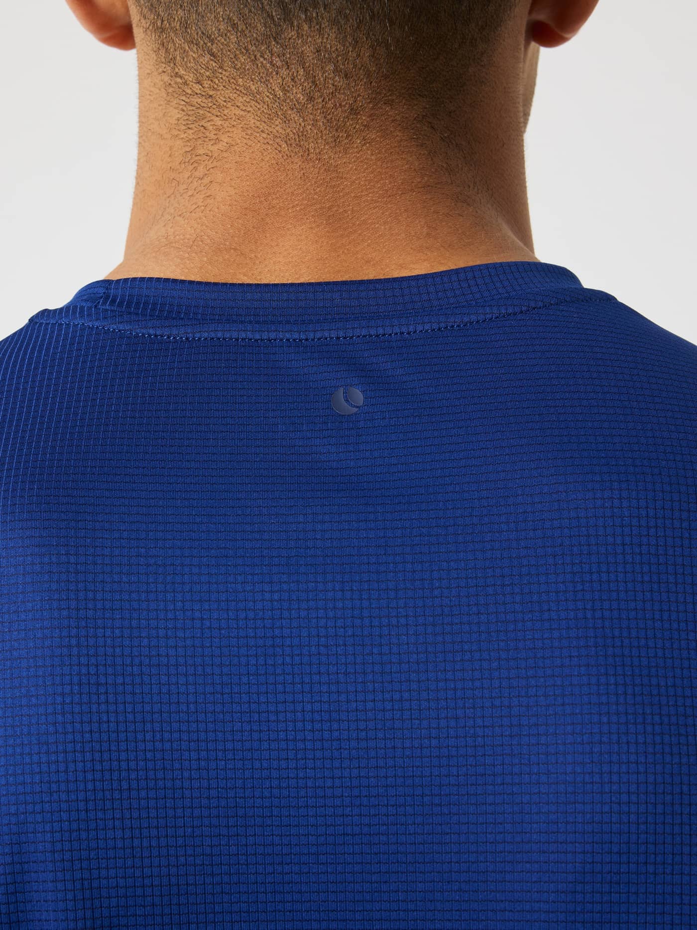 Primer plano de la nuca de la Borg Light T-Shirt en Blue Depths (Azul) con logo de pelota de tenis y tejido de entrenamiento. - Image 5