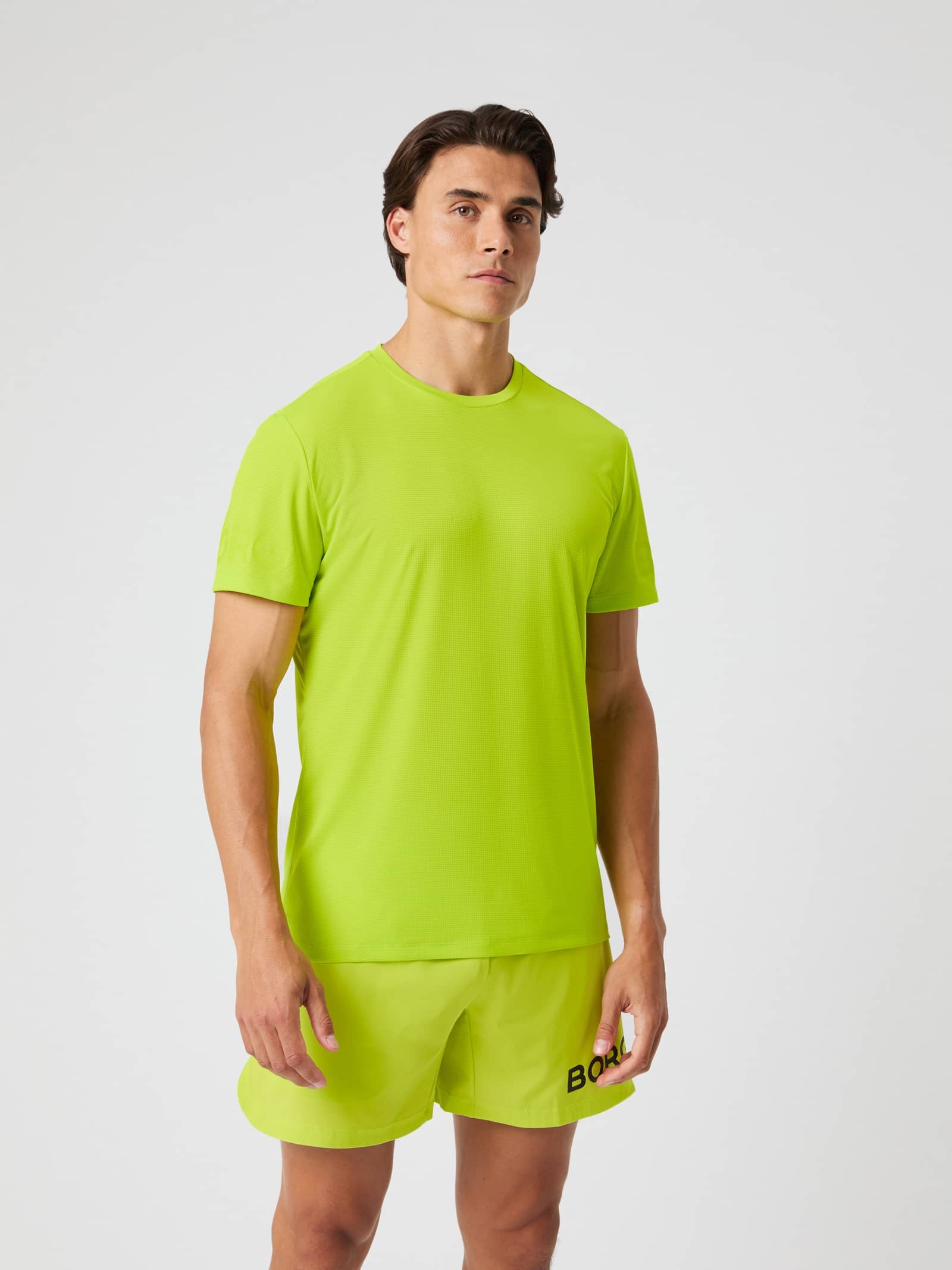 Vooraanzicht van een man in het Acid Lime (Groen) Borg Light T-Shirt voor training en tennis. - Image 1