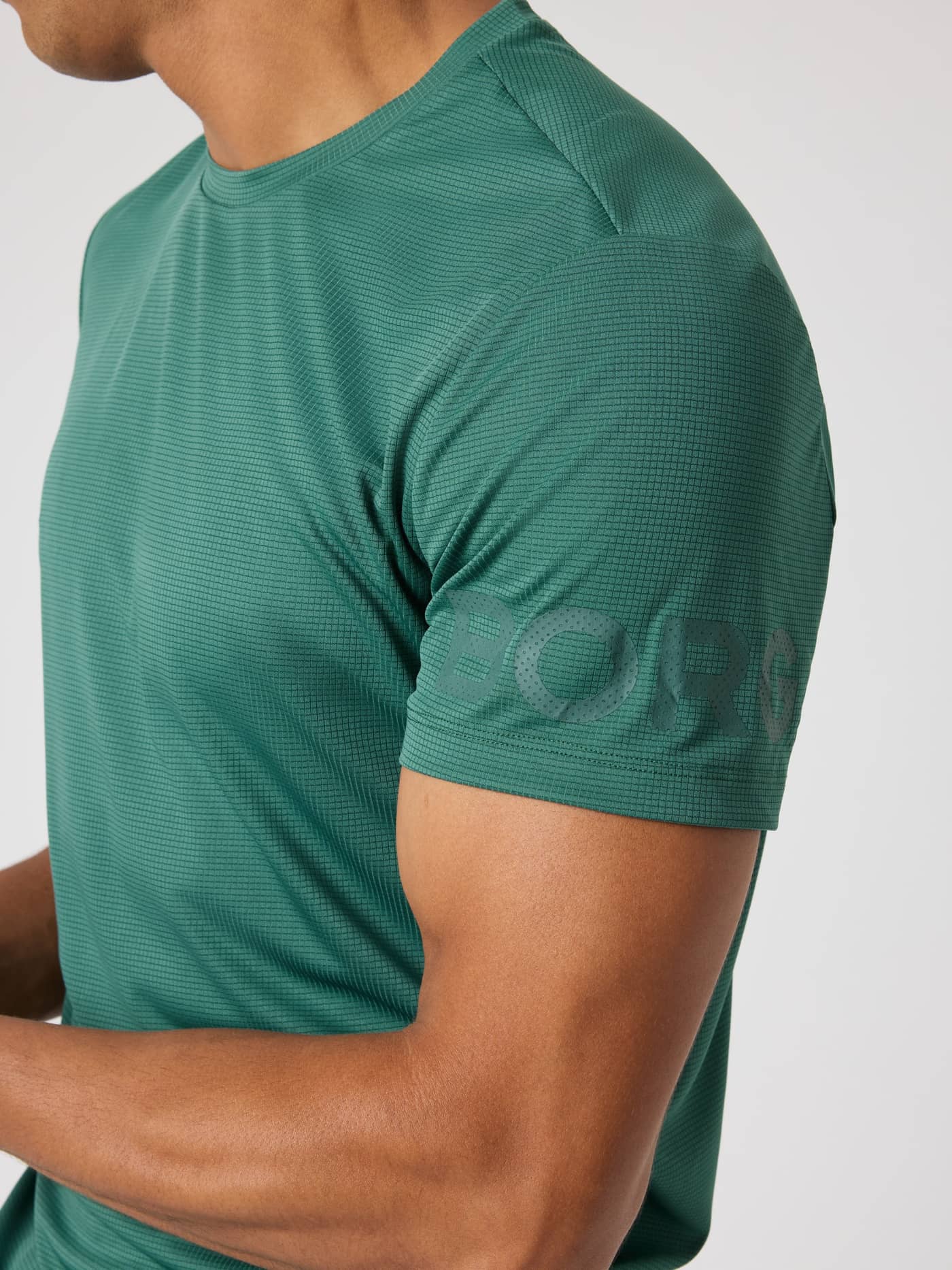 Close-up of the Borg Light T-Shirt in Mallard Green (Green) with a tonal green sleeve logo and structured training fabric. - Image 4