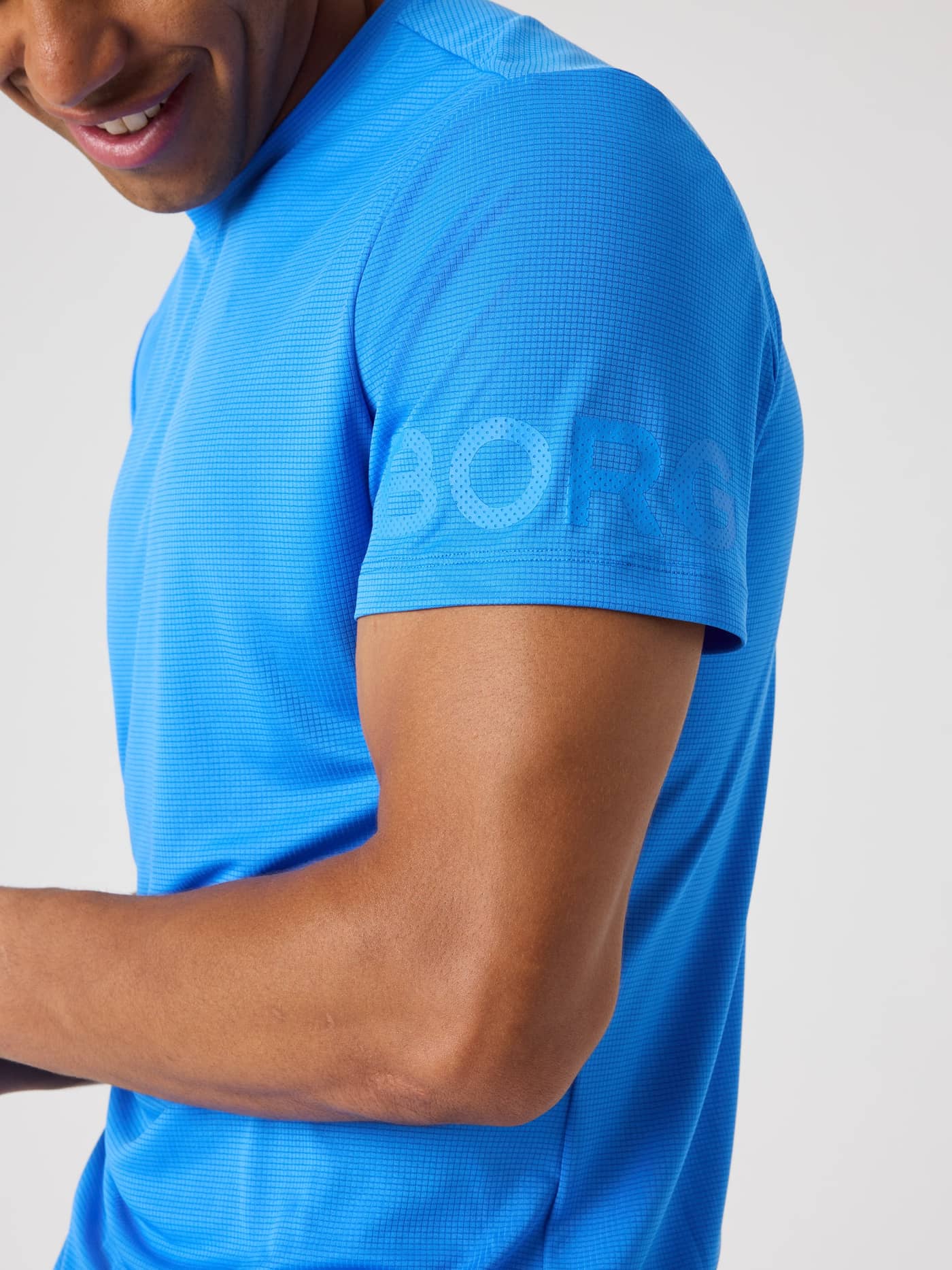 Close-up of the Borg Light T-Shirt in Palace Blue (Blue) with a sleeve logo and structured training material. - Image 4
