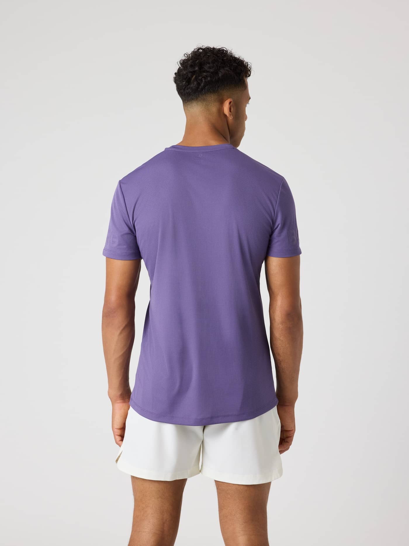 Back view of a man wearing the Björn Borg Light T-Shirt in Mystical (Purple), a performance top for training and tennis. - Image 2
