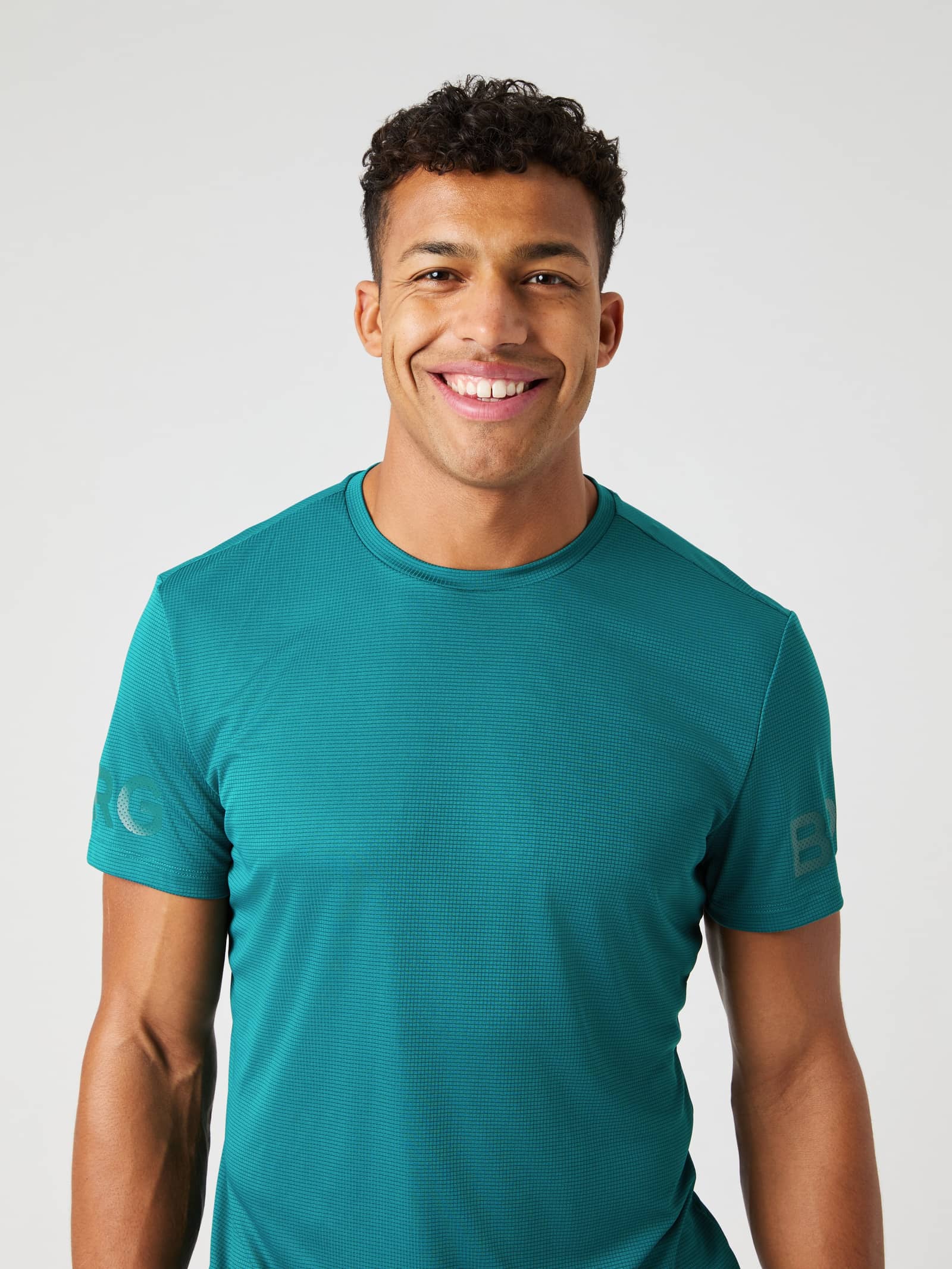 Front view of a man wearing the Shaded Spruce (Blue) Borg Light T-Shirt, a structured training and tennis jersey. - Image 1