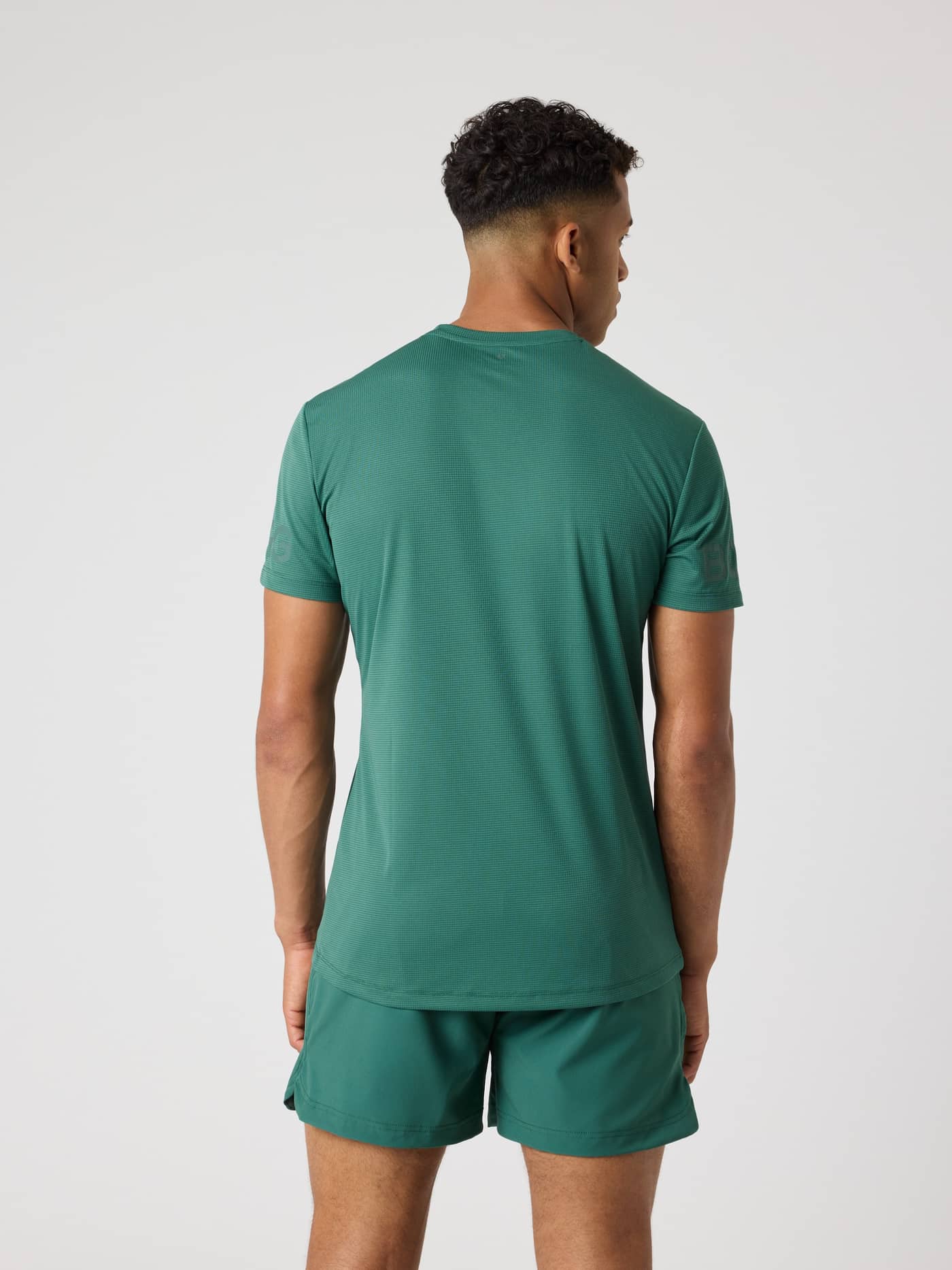 Back view of a man wearing the Borg Light T-Shirt in Mallard Green (Green), a performance training top with a longer length. - Image 2