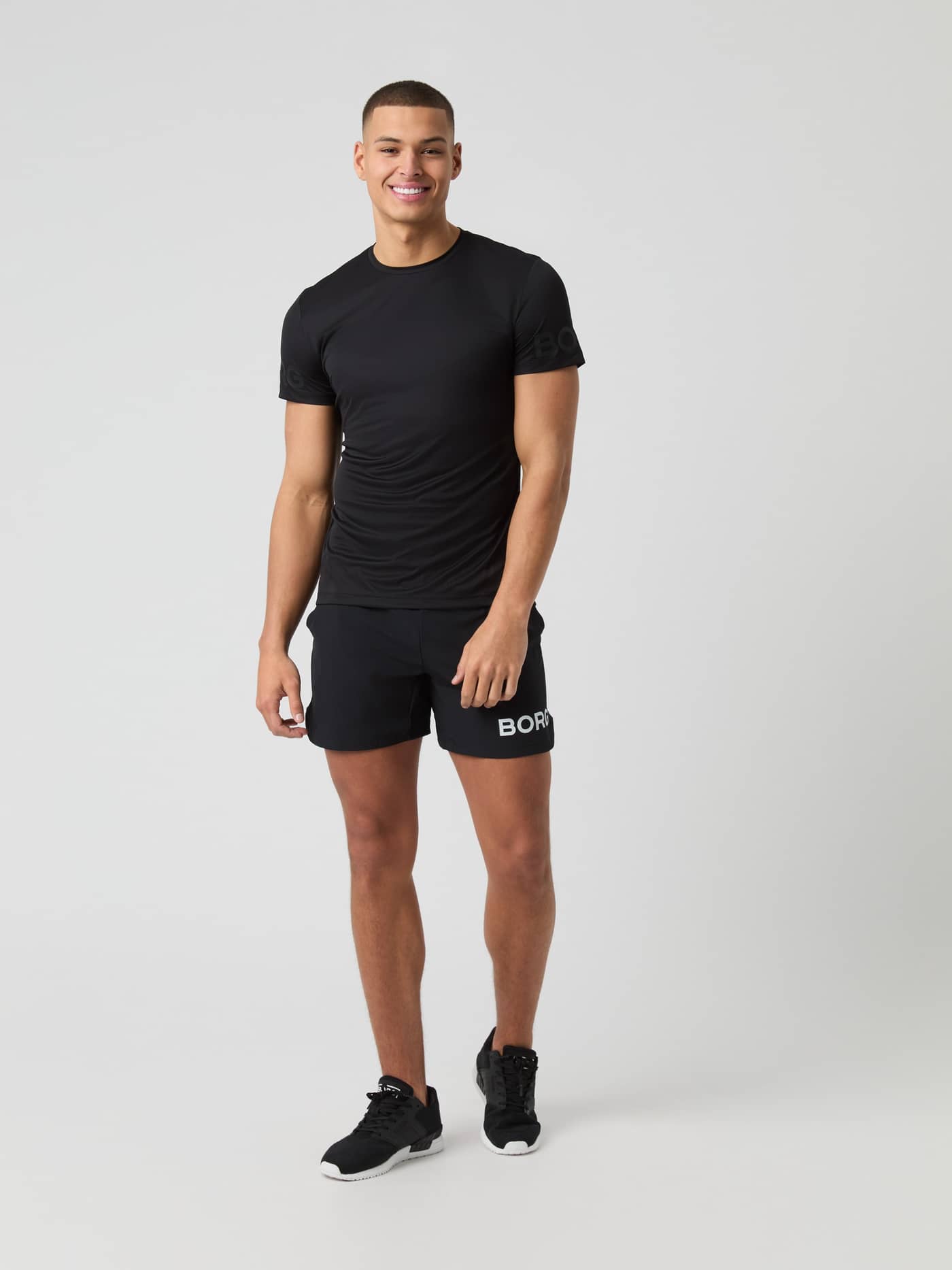 Vooraanzicht van een man in het Borg Light T-Shirt in Black Beauty (Zwart) voor training en tennis. - Image 3