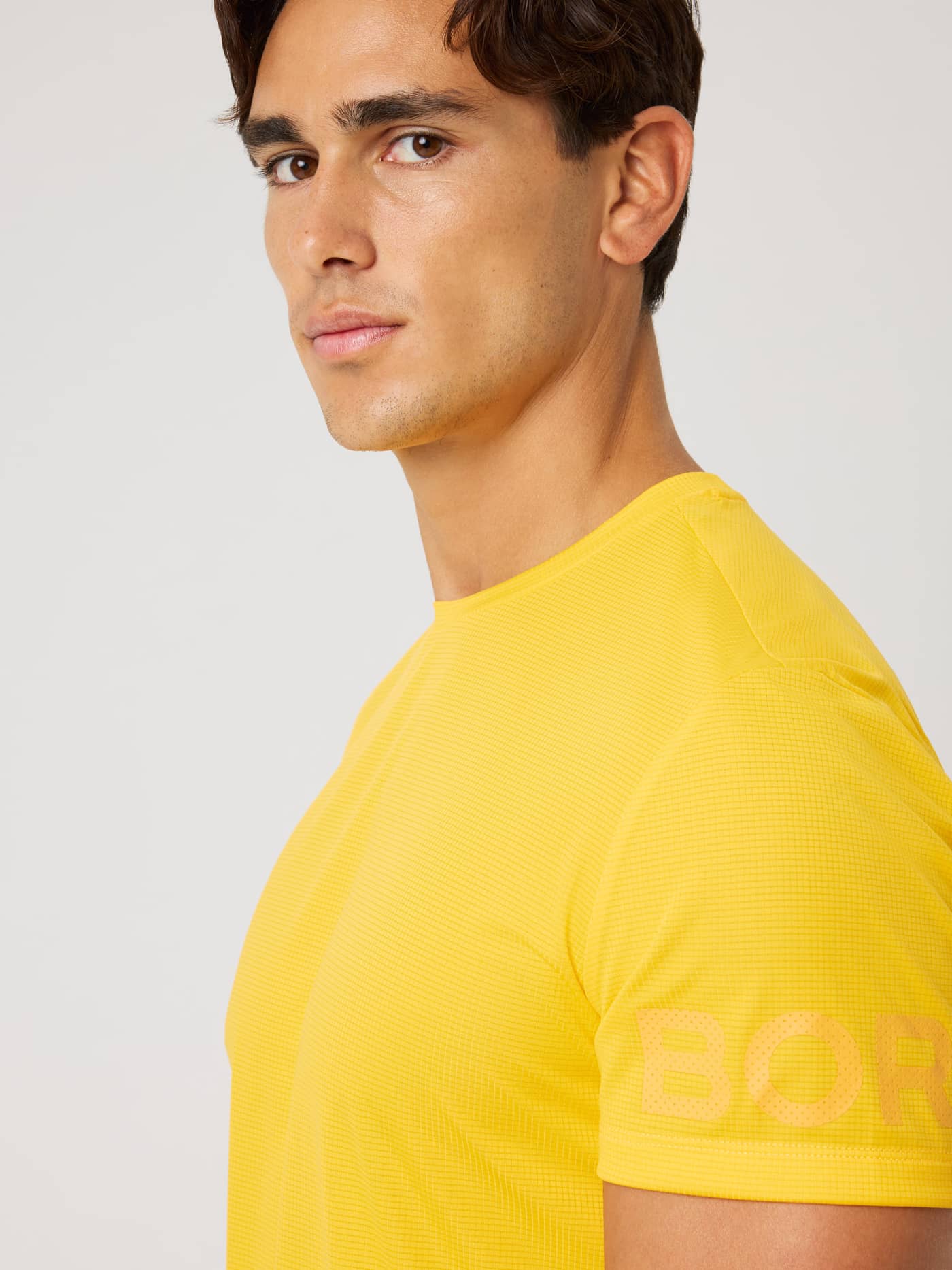 Borg Light T-Shirt i Citrus (Orange) set fra siden i et struktureret materiale med ton-i-ton logo til træning. - Image 5