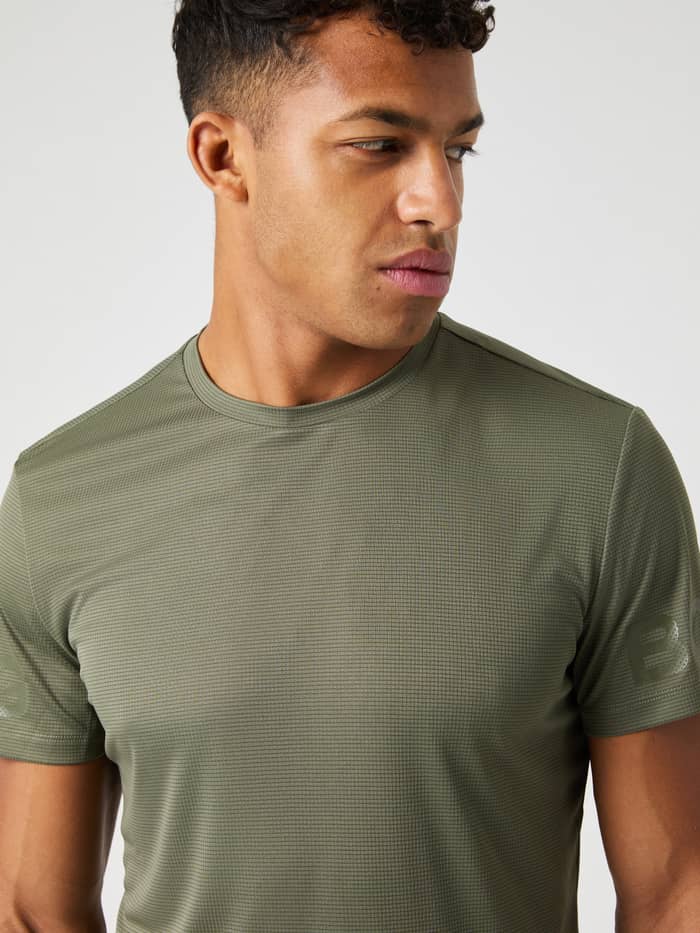 Nærbillede af en mand i Borg Light T-Shirt i Dusty Olive (Grøn) med struktureret træningsstof og tonale grønne logoer. - Image 4