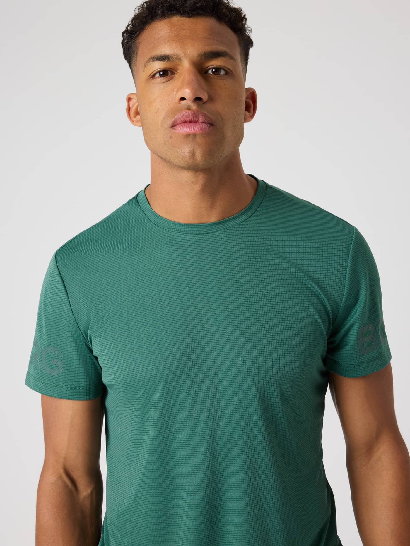 Front view of a man in the Mallard Green (Green) training Borg Light T-Shirt with tonal logos and structured tennis jersey. - Image 5