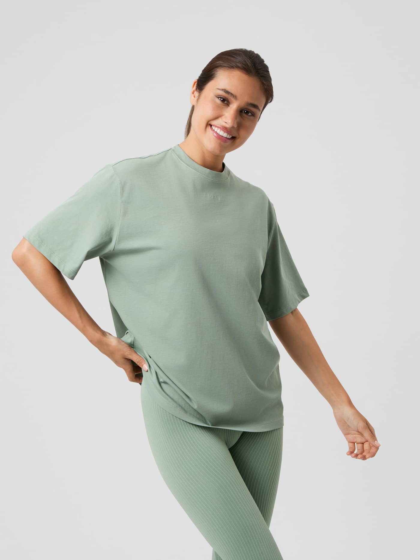Woman wearing the light green Björn Borg Studio Oversized T-shirt, seen from the front in a studio setting. - Image 1