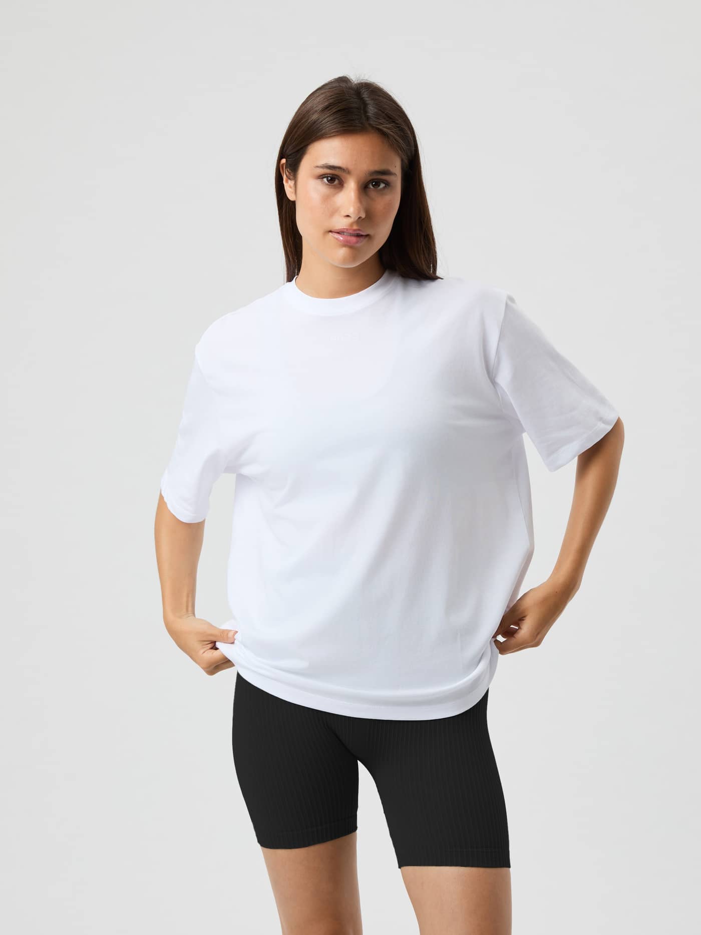 Vue de face d'une femme portant le Studio Oversized T-Shirt en Brilliant White (Blanc) pour l'entraînement en studio. - Image 3