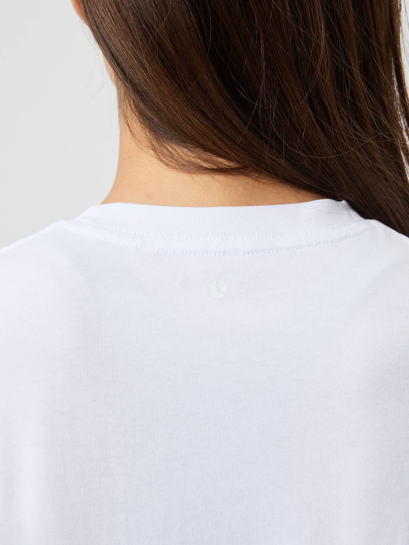 Gros plan de l'encolure dos du Studio Oversized T-Shirt Brilliant White (Blanc) pour le training en coton mélangé. - Image 5