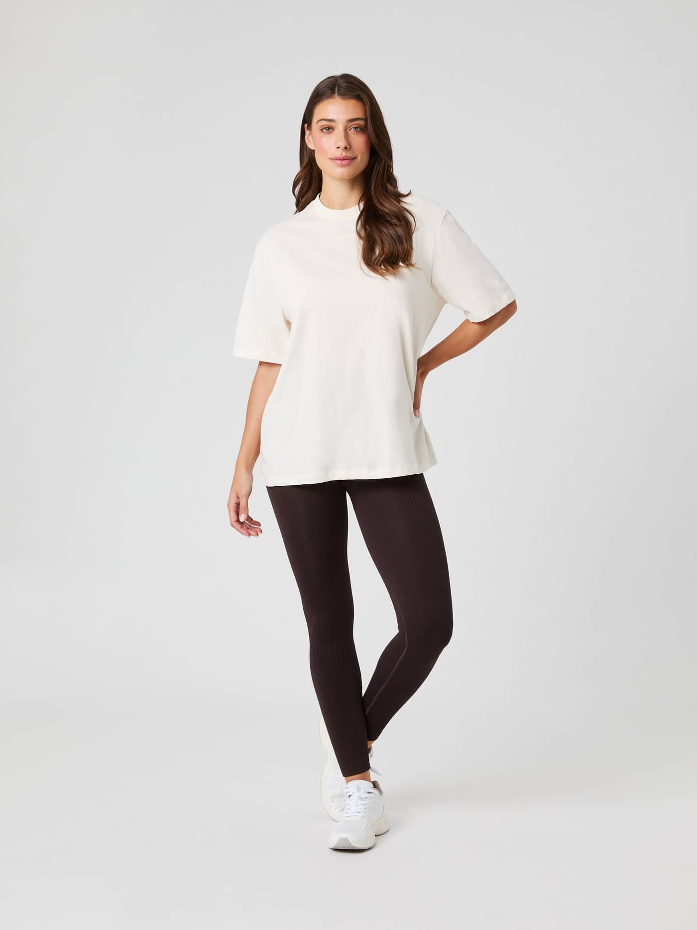 Modelo frontal con la Studio Oversized T-Shirt en Tofu (Blanco), leggings y zapatillas con ajuste holgado y estilo. - Image 3