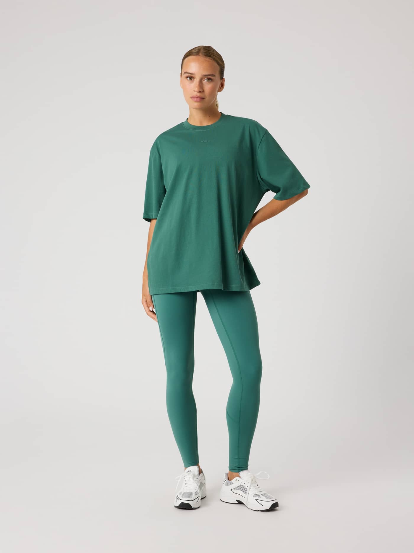 Full-body view of a model wearing the Mallard Green (Green) Studio Oversized T-Shirt, featuring a loose, stylish fit. - Image 3