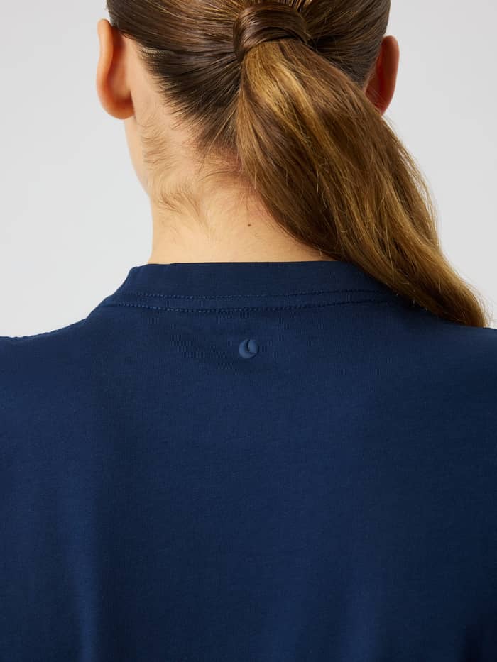 Back view of the Studio Oversized T-Shirt in dress blues (blue), highlighting the round neck and subtle tonal logo detail.