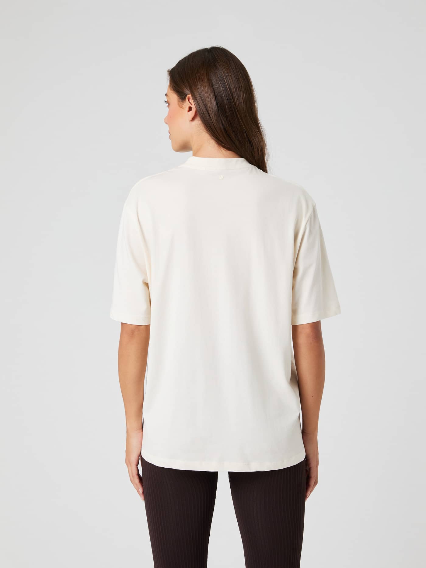Vista posterior de una modelo con la Studio Oversized T-Shirt en Tofu (Blanco) de mezcla de algodón y ajuste holgado. - Image 2