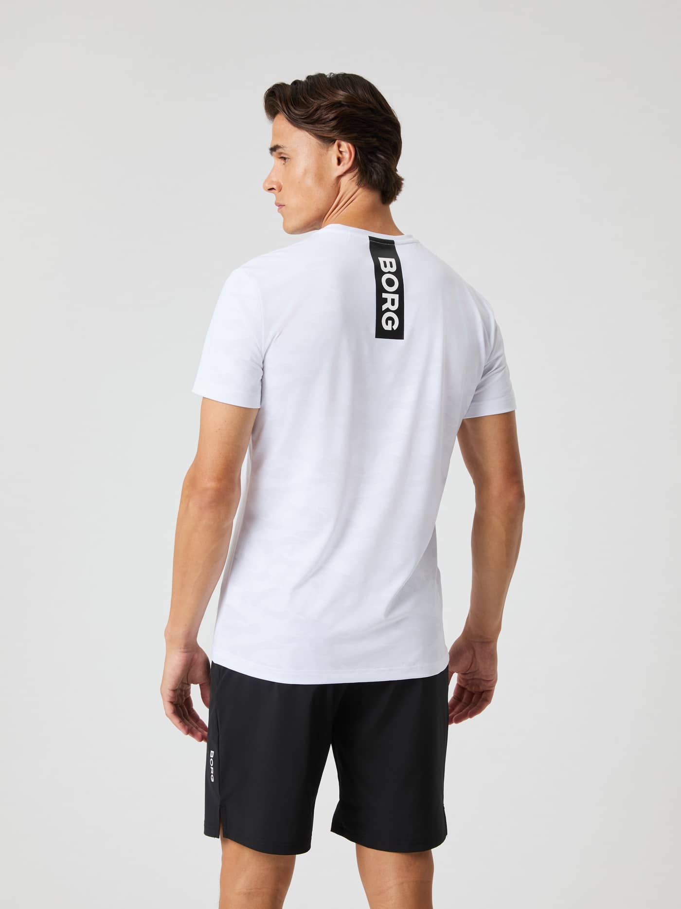 Borg Performance T-Shirt i Brilliant White (Hvid) set bagfra med camomønster og sort logo til træning og tennis. - Image 2