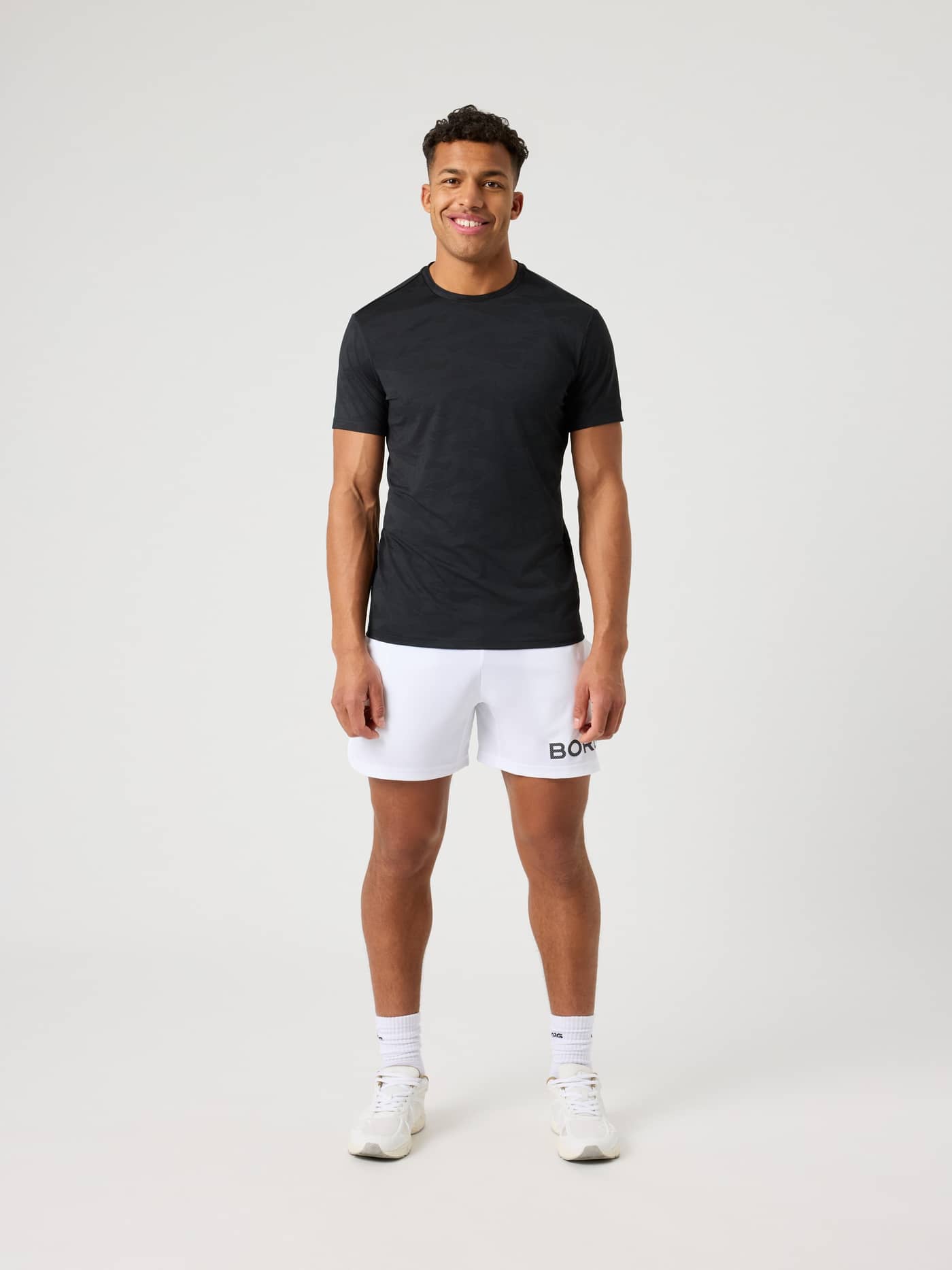 Vorderansicht eines Mannes im Borg Performance T-Shirt in Black Beauty (Schwarz) mit Camo-Muster für Training und Tennis. - Image 3