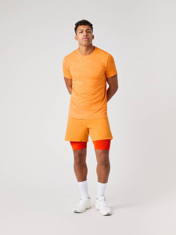 Vooraanzicht van een man in het Borg Performance T-Shirt in Sun Orange (Oranje) met camo voor training. - Image 4