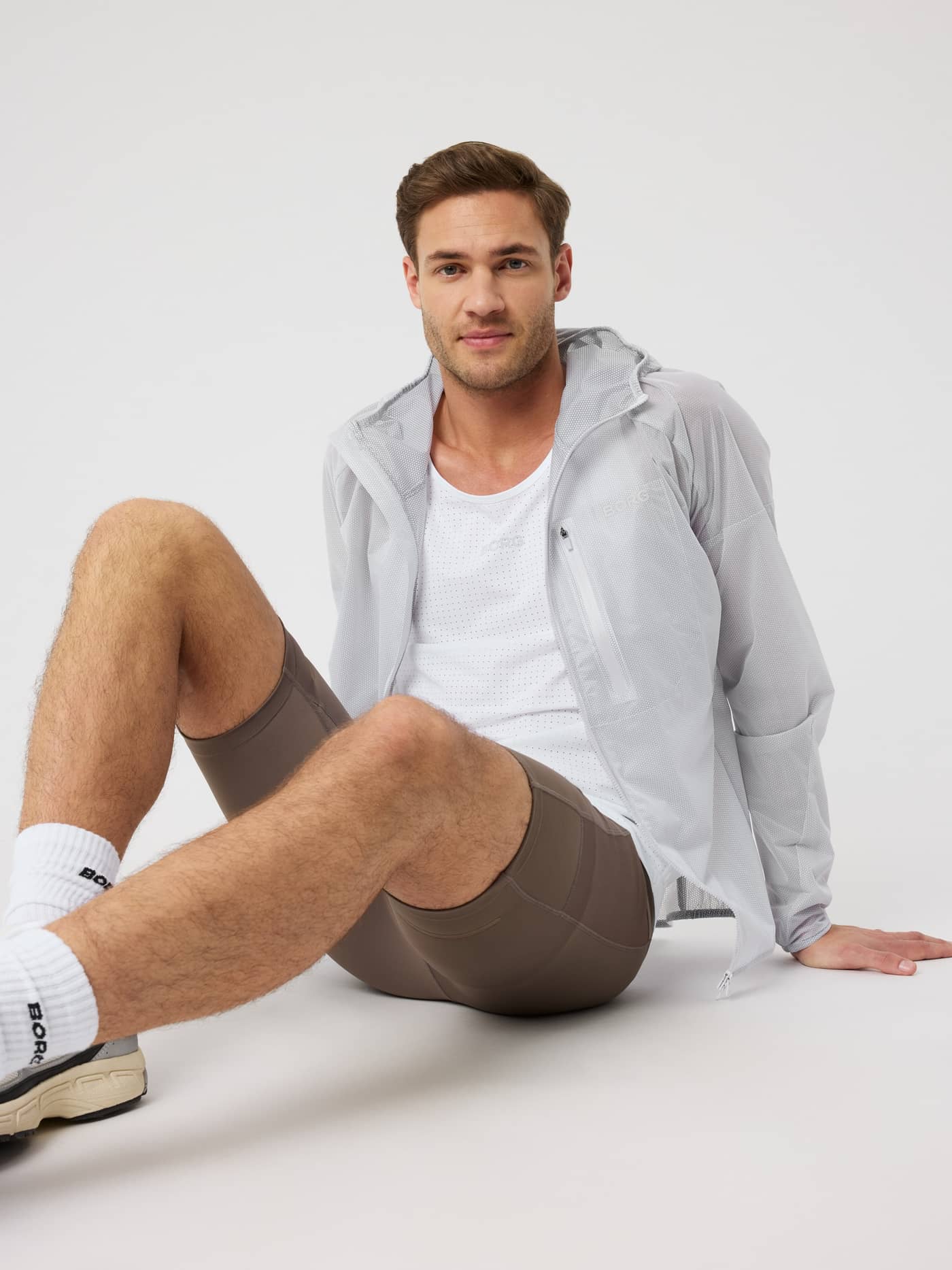 Sitzender Mann in der Borg Running Jacket in Brilliant White (Weiß), eine funktionelle Polyamidschicht für Running. - Image 4
