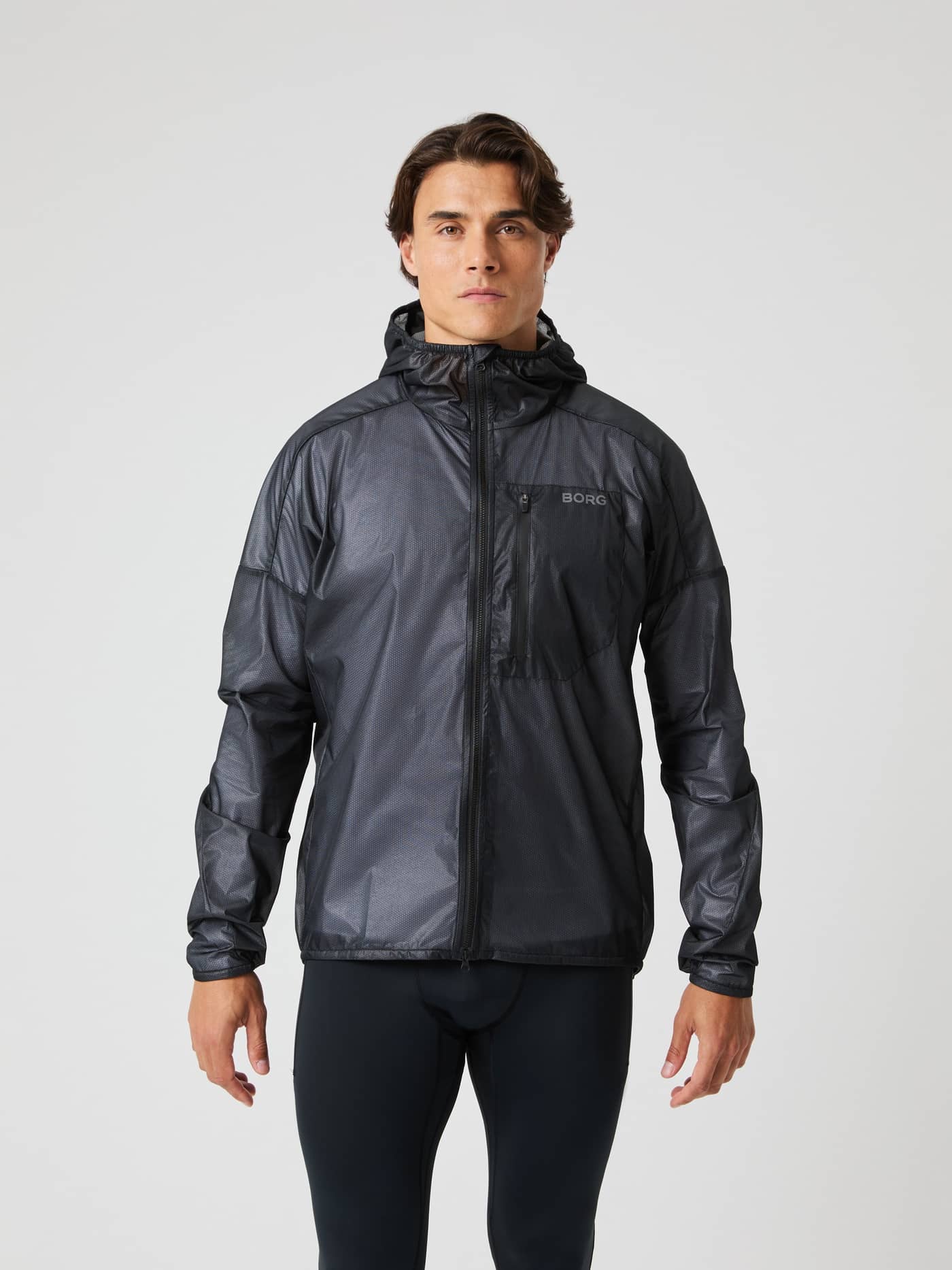 Front view of a man wearing the stylish Björn Borg Performance Jacket in Black Beauty (Black) for running with a grey logo. - Image 1