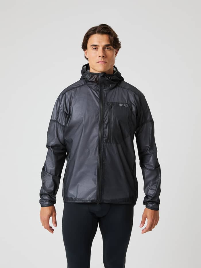 Vooraanzicht van een man in de Björn Borg Performance Jacket in Black Beauty (Zwart) met grijs logo voor hardlopen. - Image 1