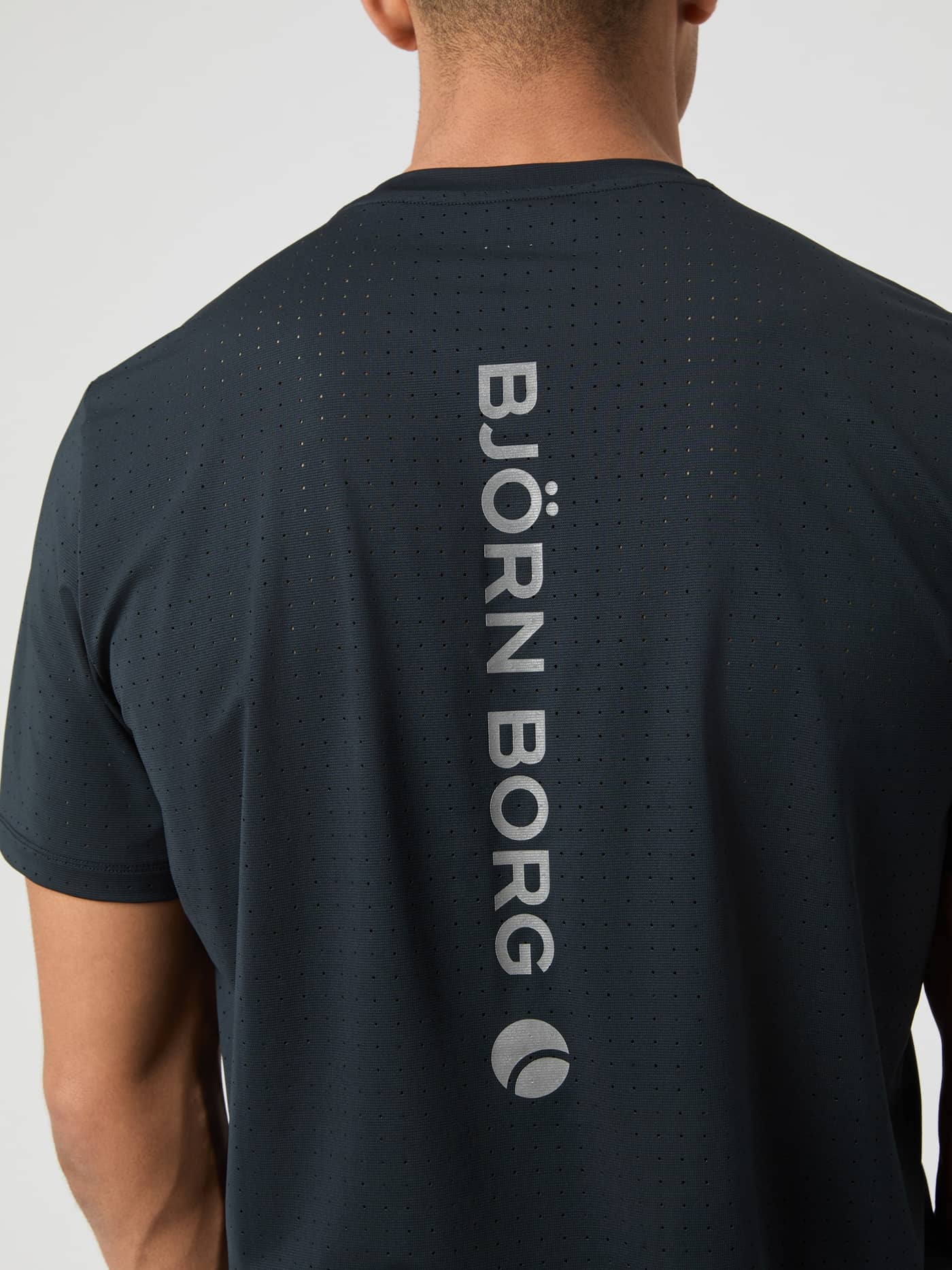 Back view of the Borg Performance Perforated T-Shirt in Black Beauty (Black) with a reflective silver logo for running. - Image 4