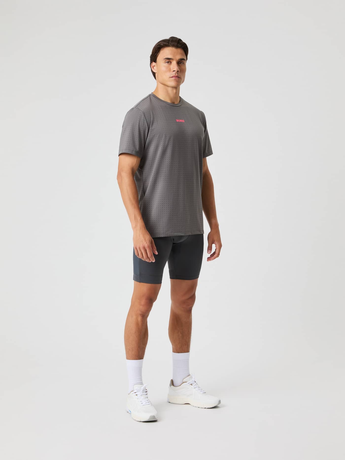 Ganzkörperansicht eines Mannes im Borg Performance Perforated T-Shirt in Granite Gray (Grau) zum Laufen mit pinkem Logo. - Image 4