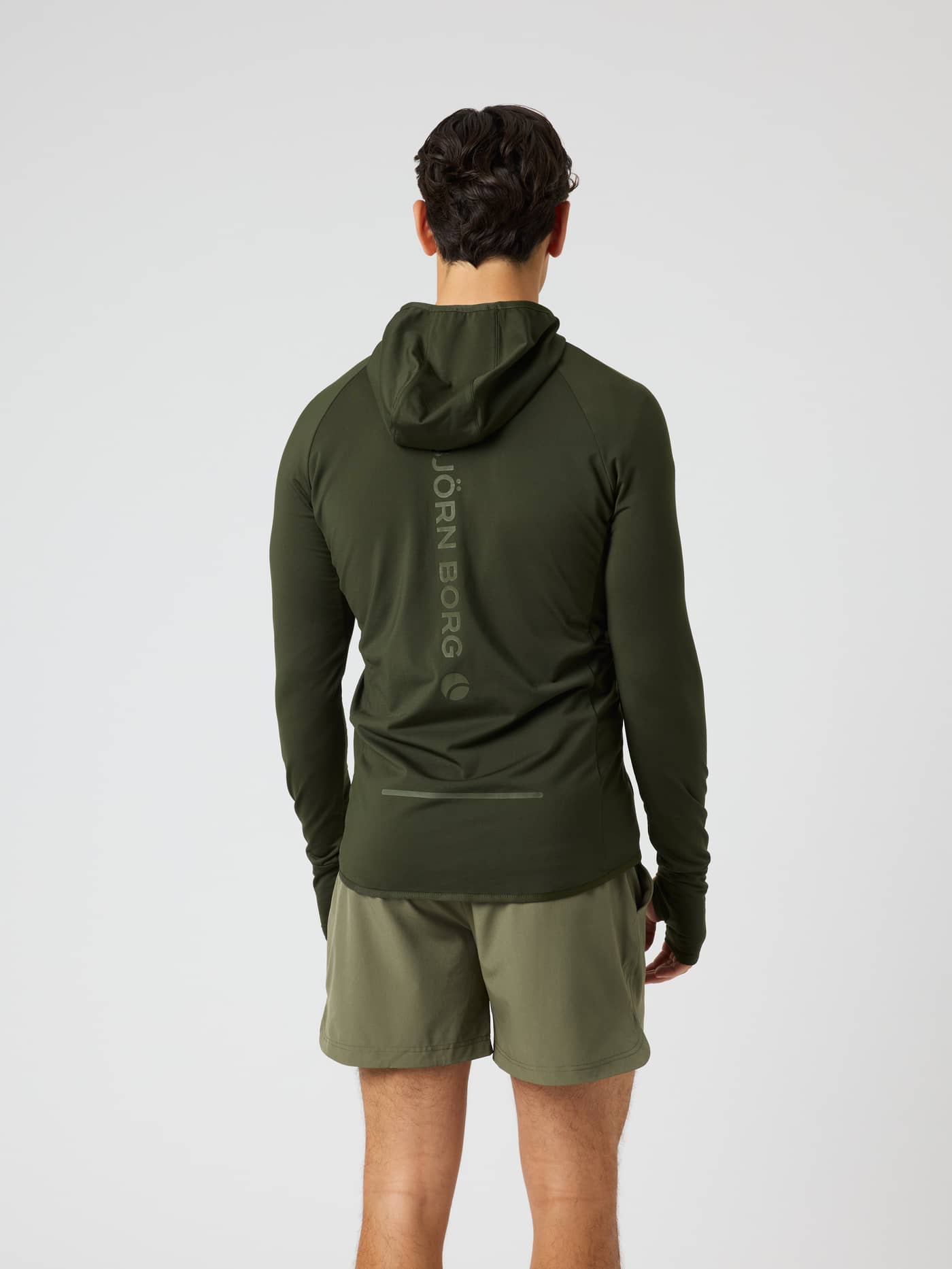 Back view of a man wearing the Borg Performance Mid Layer Hood in Rosin (Green) for running with a reflective logo. - Image 2