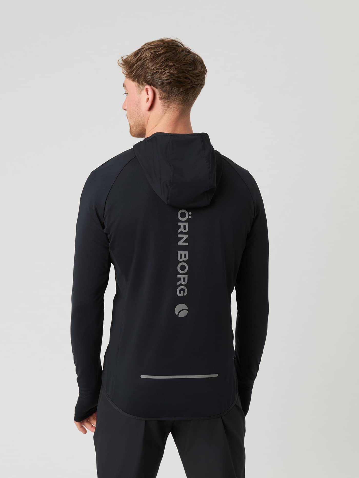 Back view of a man wearing the Borg Running Mid Layer Hood in Black Beauty (Black) with a reflective silver back logo. - Image 2