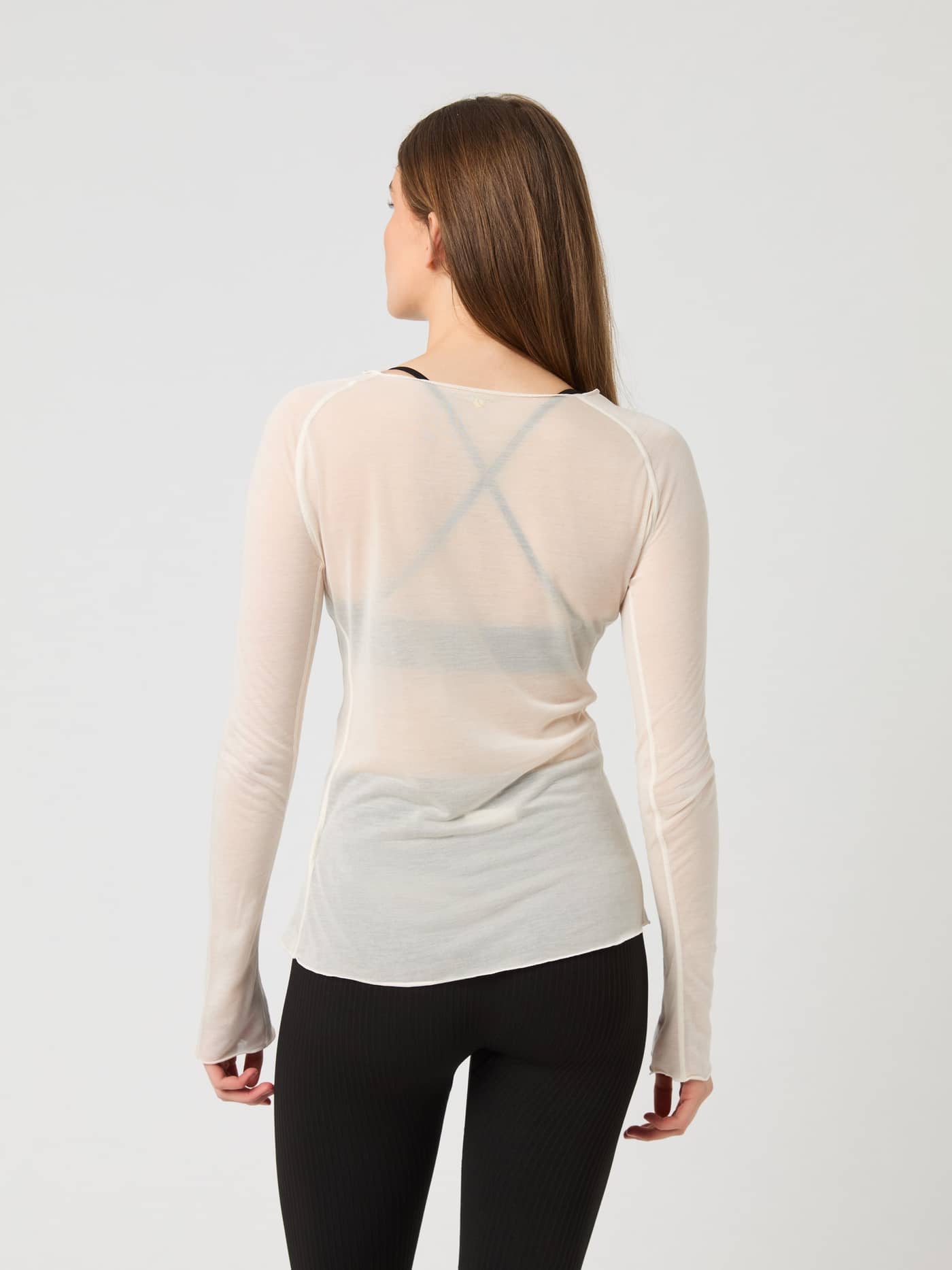Back view of a model wearing the semi-transparent Björn Borg Studio Light Long Sleeve Top in birch. - Image 3