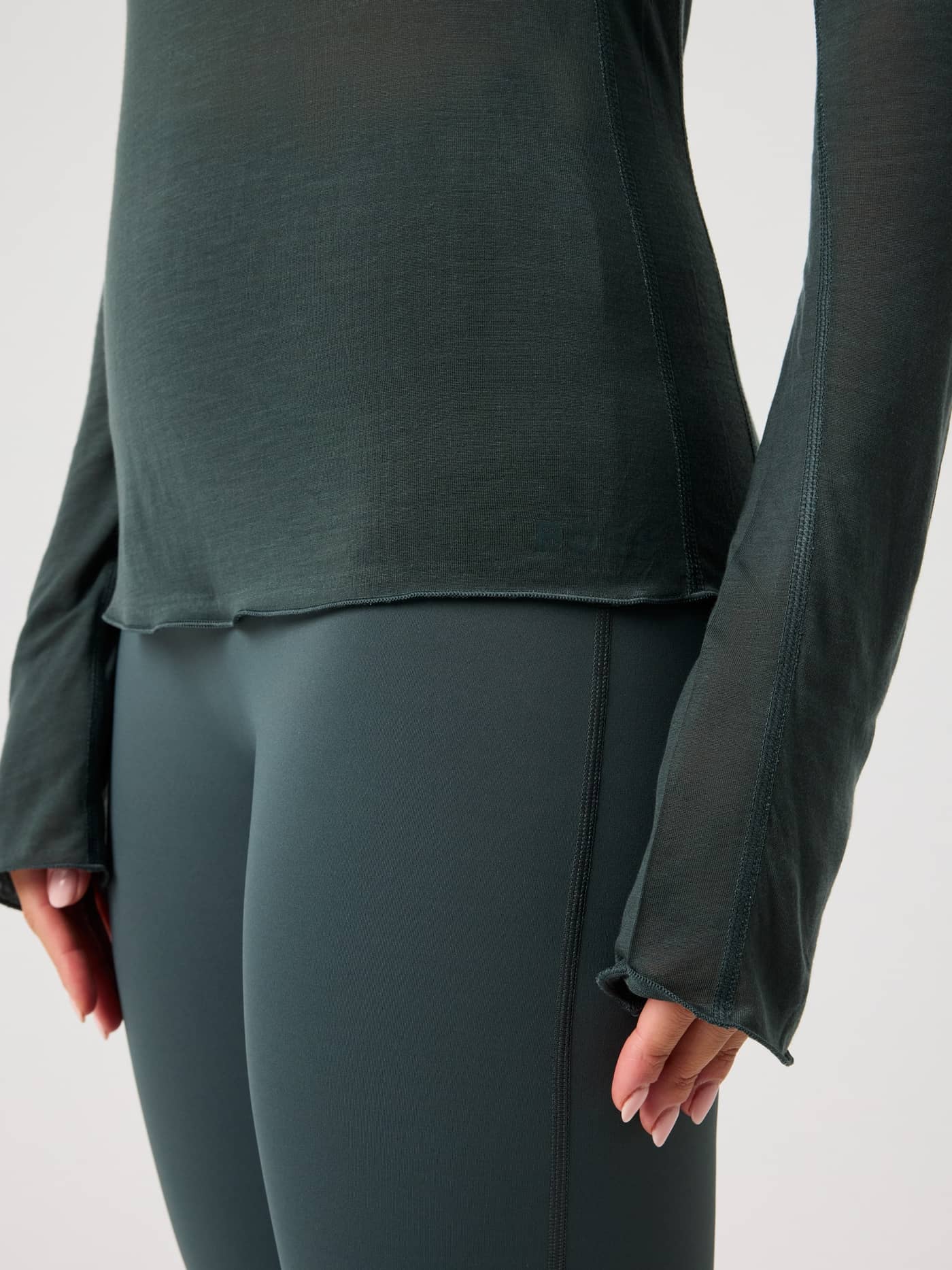 Detailed close-up of the Studio Light Long Sleeve Top in Urban Chic (Green), showcasing the semi-transparent training fabric. - Image 5