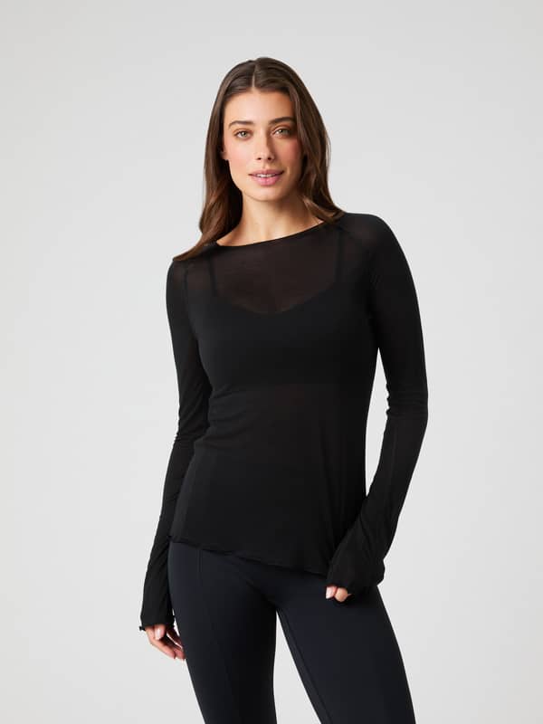 Vorderansicht einer Frau im schmalen Björn Borg Studio Light Long Sleeve Top in Black Beauty (Schwarz) für Training.