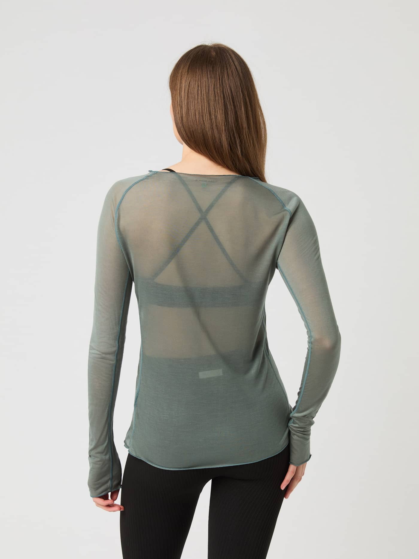Back view of a model wearing the Björn Borg Studio Light Long Sleeve Top in semi-transparent agave green fabric. - Image 3