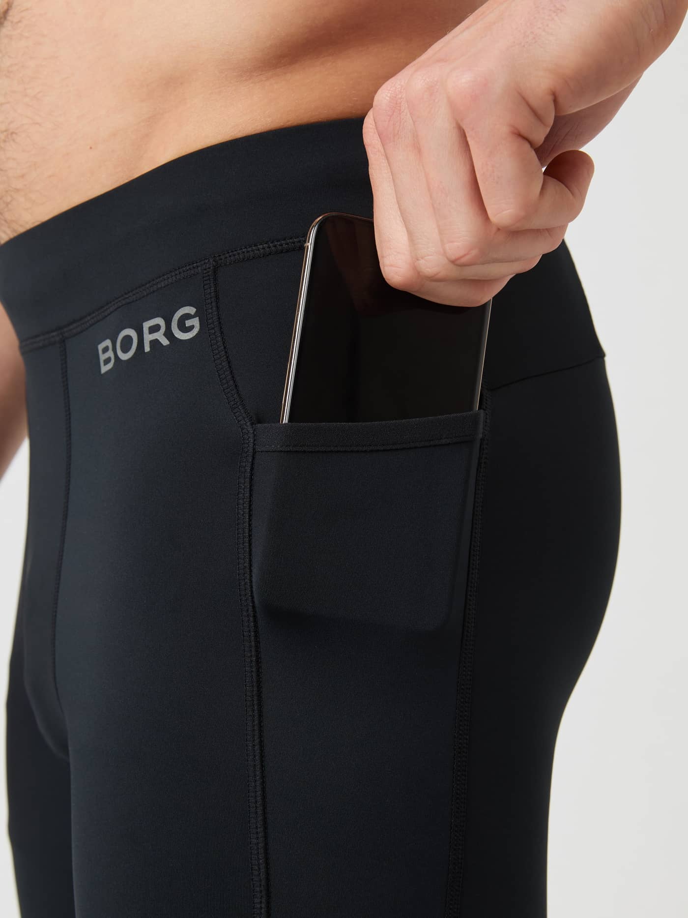 Bolsillo lateral funcional para el teléfono en las Borg Running Tights para hombre en Black Beauty (Negro) con logo gris. - Image 3