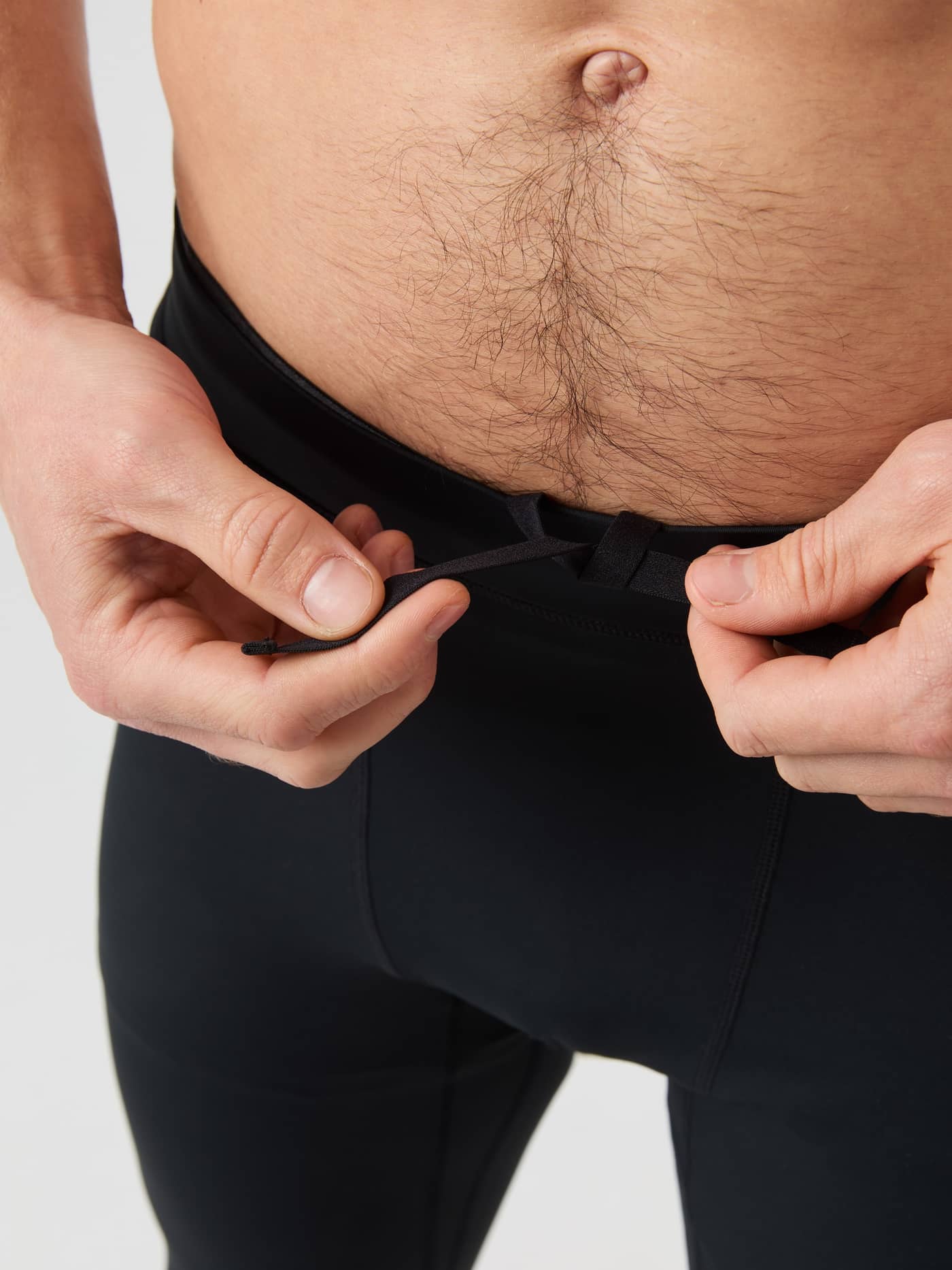 Primer plano del hombre ajustando el cordón de las Borg Running Tights en Black Beauty (Negro) para estilo y running. - Image 4