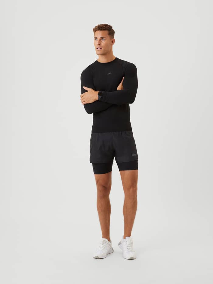 Ganzkörperansicht eines Mannes in funktionellen Borg Running Shorts 2 In 1 in Black Beauty (Schwarz) für Laufen und Training. - Image 3