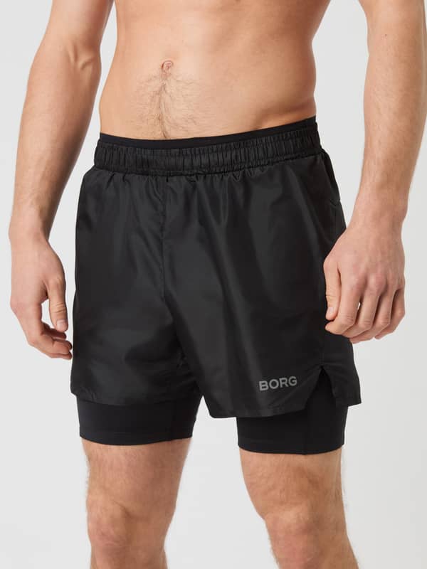 Front view of a model wearing the Borg Running Shorts 2 In 1 in Black Beauty (Black) with a grey logo for running.